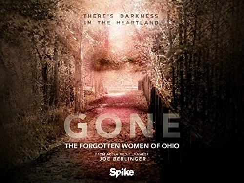 A dirt path surrounded by trees with pink and brown foliage, with text overlay about the film "Gone: The Forgotten Women of Ohio" by Joe Berlinger.