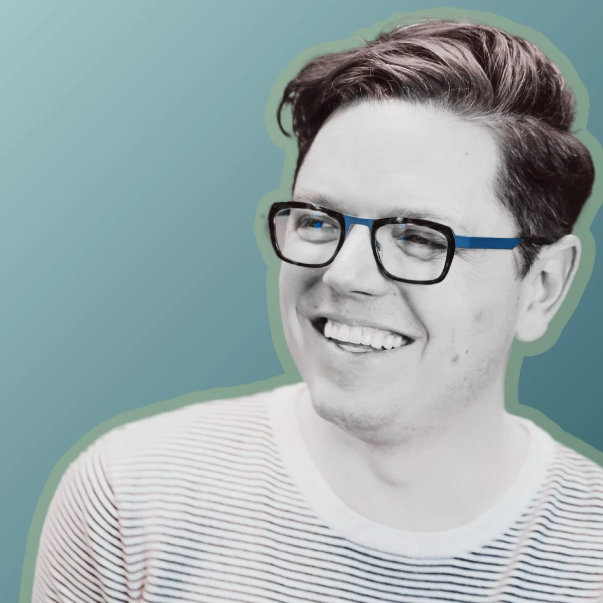 David Peck, smiling, in a striped sweater and blue-framed glasses