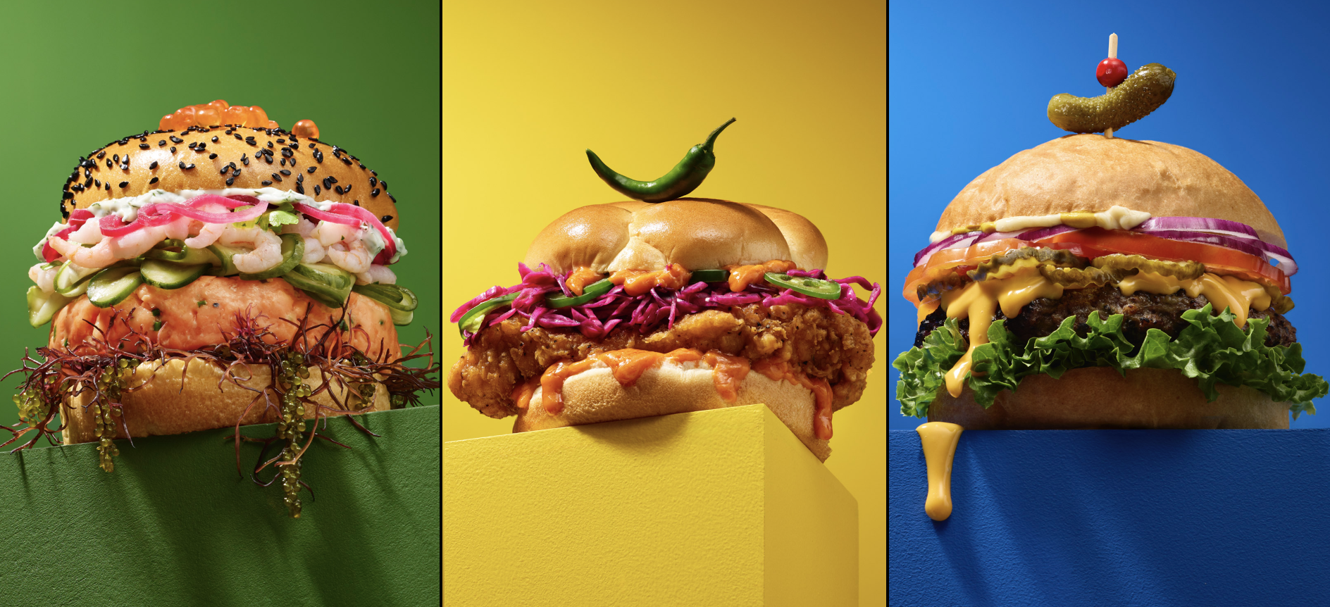 Colorful commercial food styling featuring a seafood salmon burger, fried chicken sandwich, and cheeseburger by Phoenix food stylist Suworoff Food Styling.