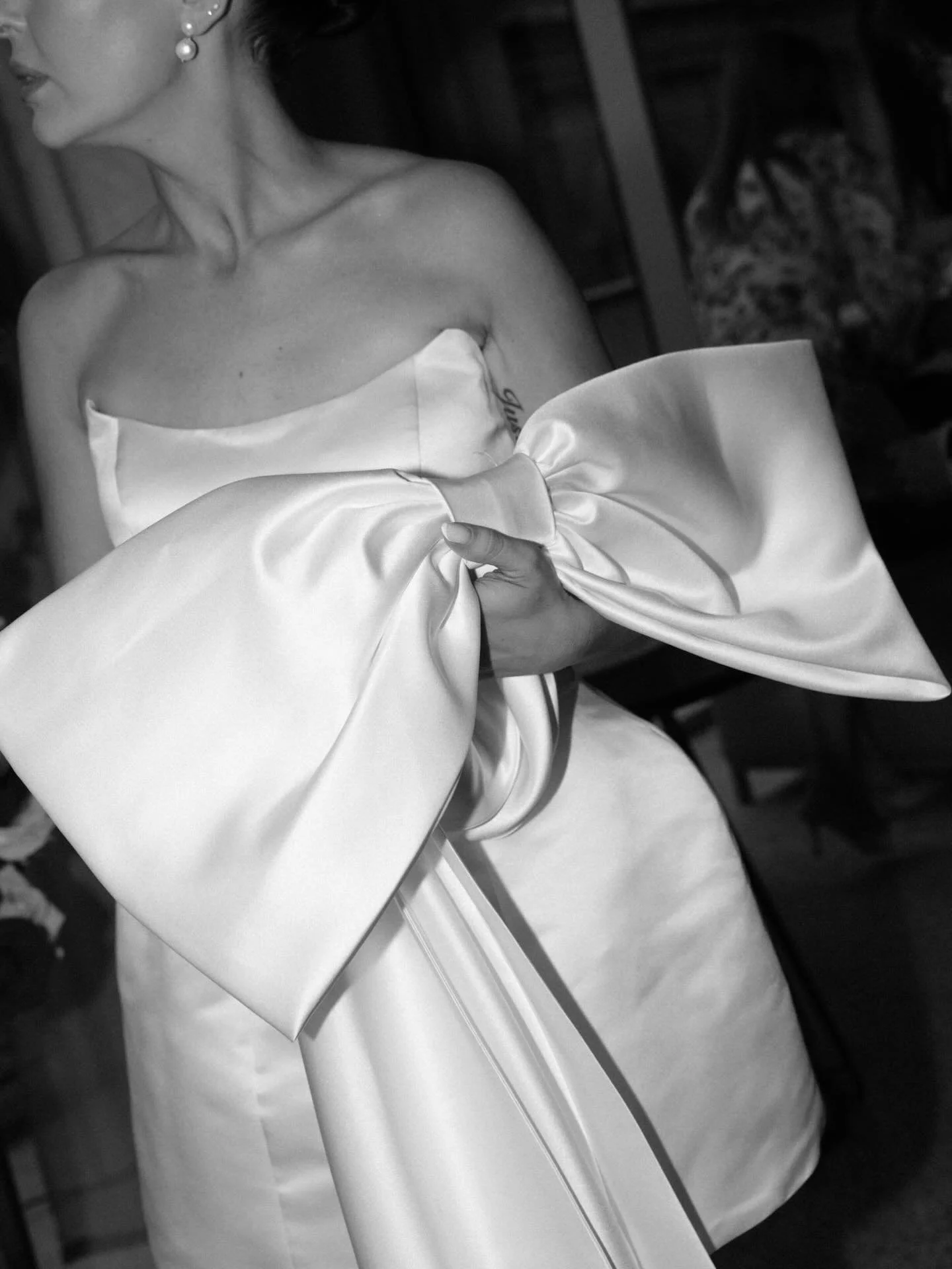 Holly&rsquo;s chic party dress, adorned with a statement back bow and flowing drapes, is the epitome of sophistication for a wedding celebration at Alto Events.