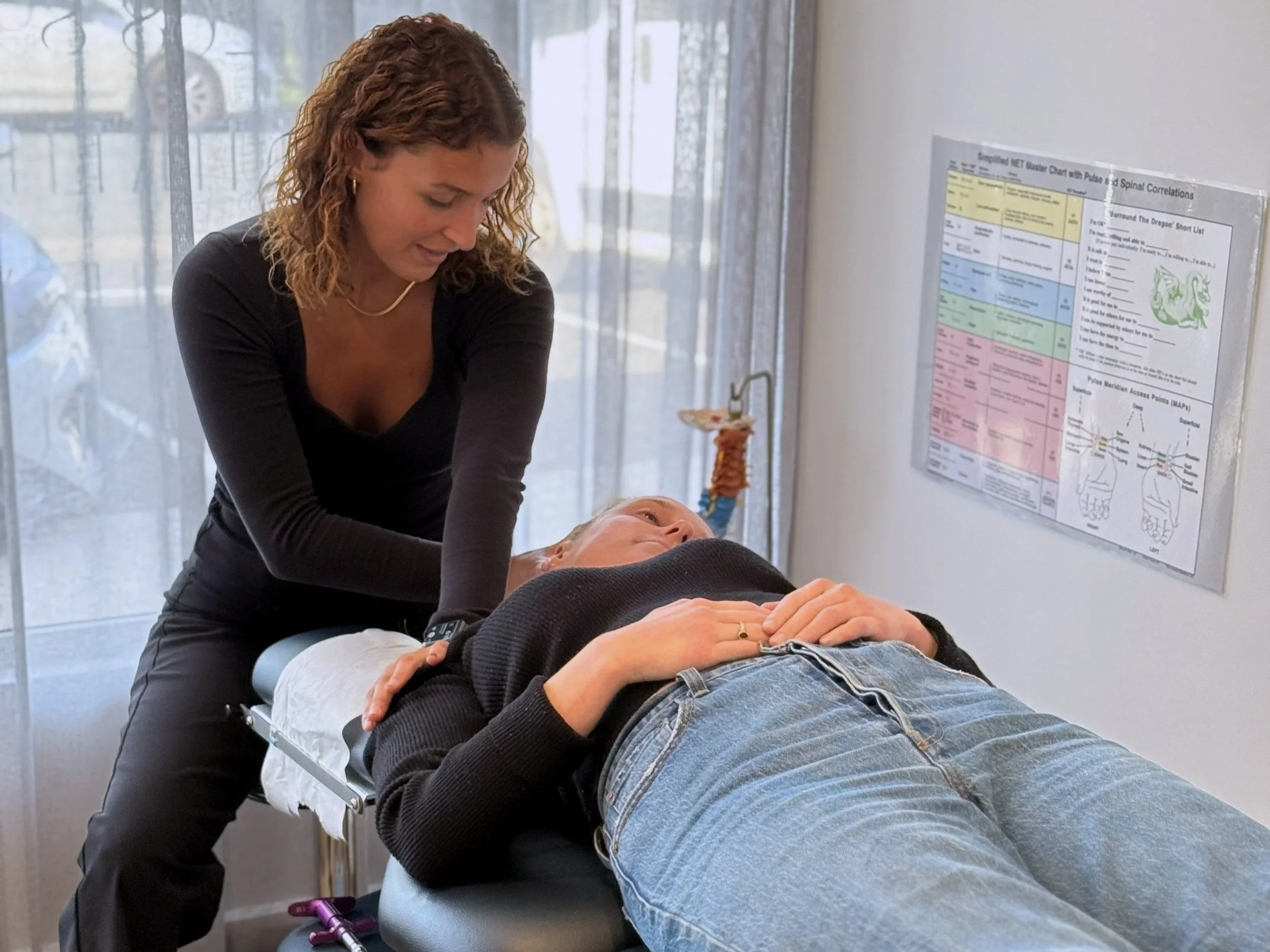 A Chiropractor supporting a woman using Neuro Emotional Technique or NET