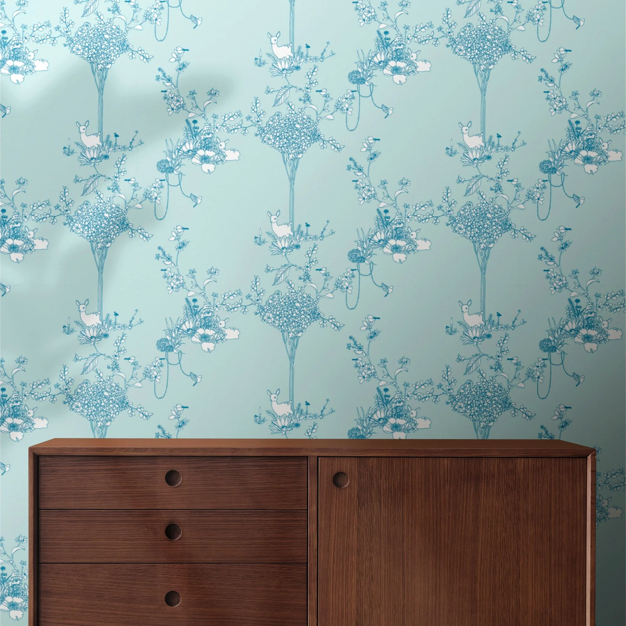 Room with decorative floral wallpaper featuring deer and birds in blue on a light blue background, and a wooden sideboard with drawers.