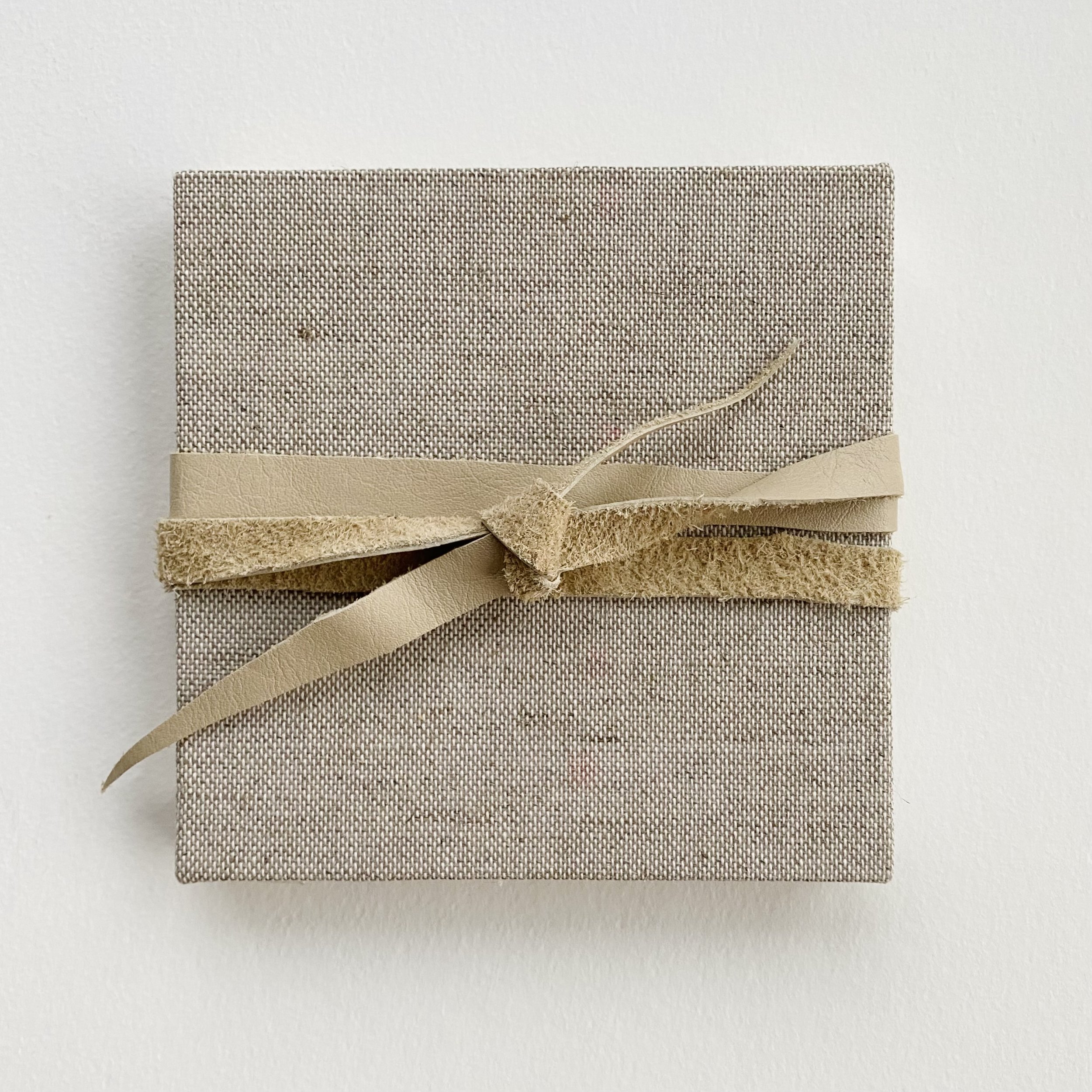 Photo book covered with tweed book cloth and secured with a leather “belt” and filled with photos of a summer family visit. 5” square accordion.