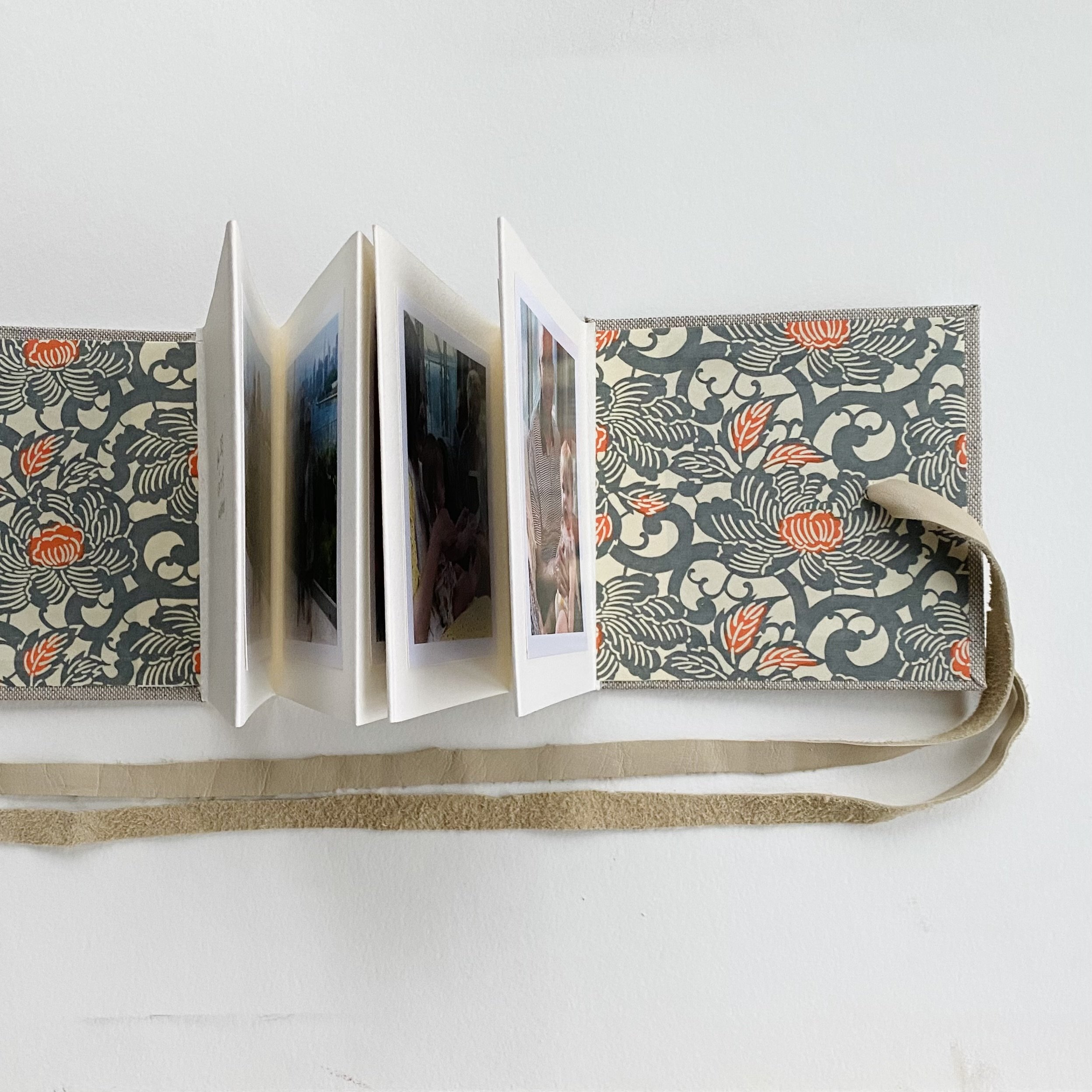 Photo book covered with tweed book cloth and secured with a leather “belt” and filled with photos of a summer family visit. 5” square accordion.