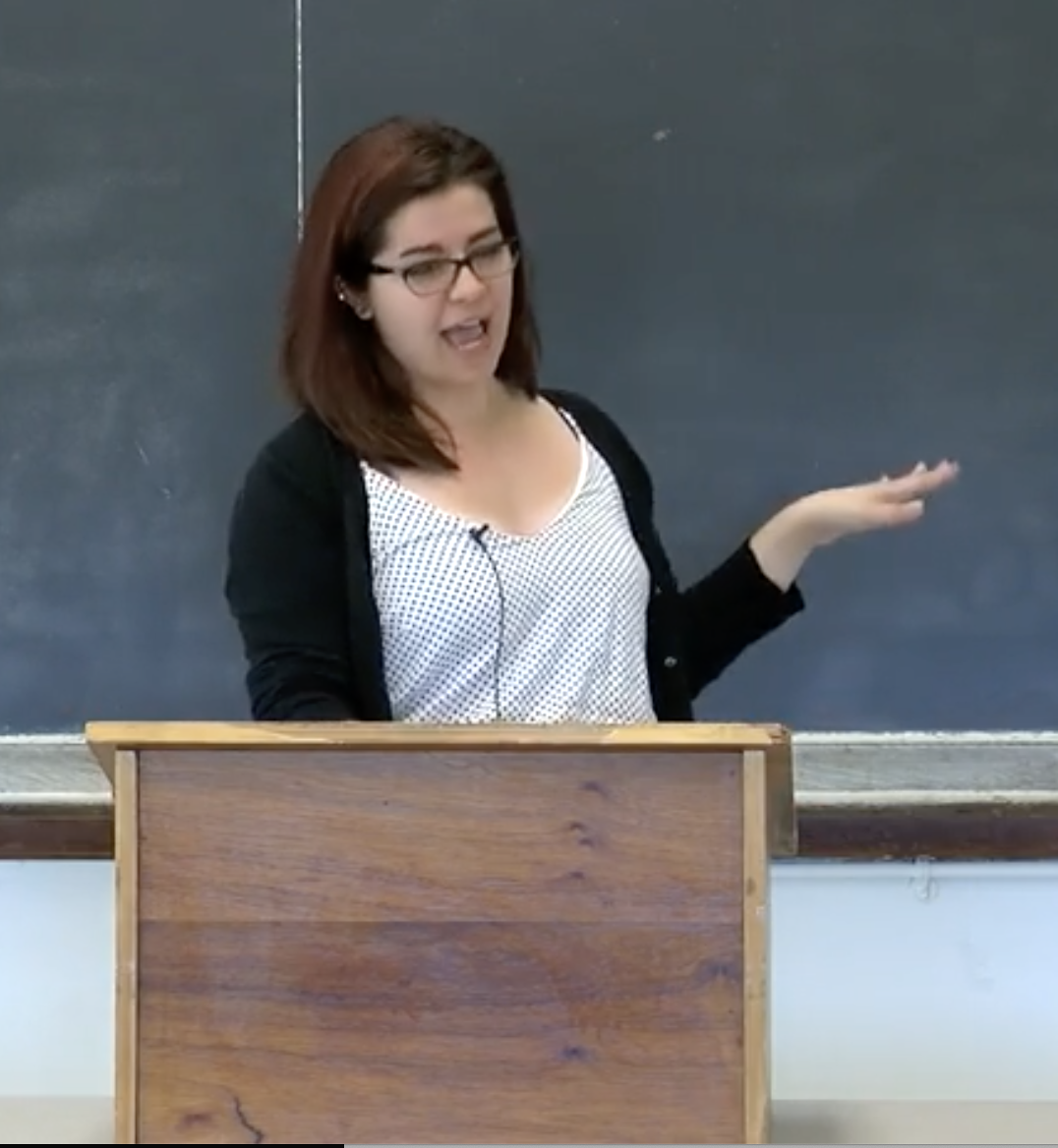 person delivering a speech behind a podium