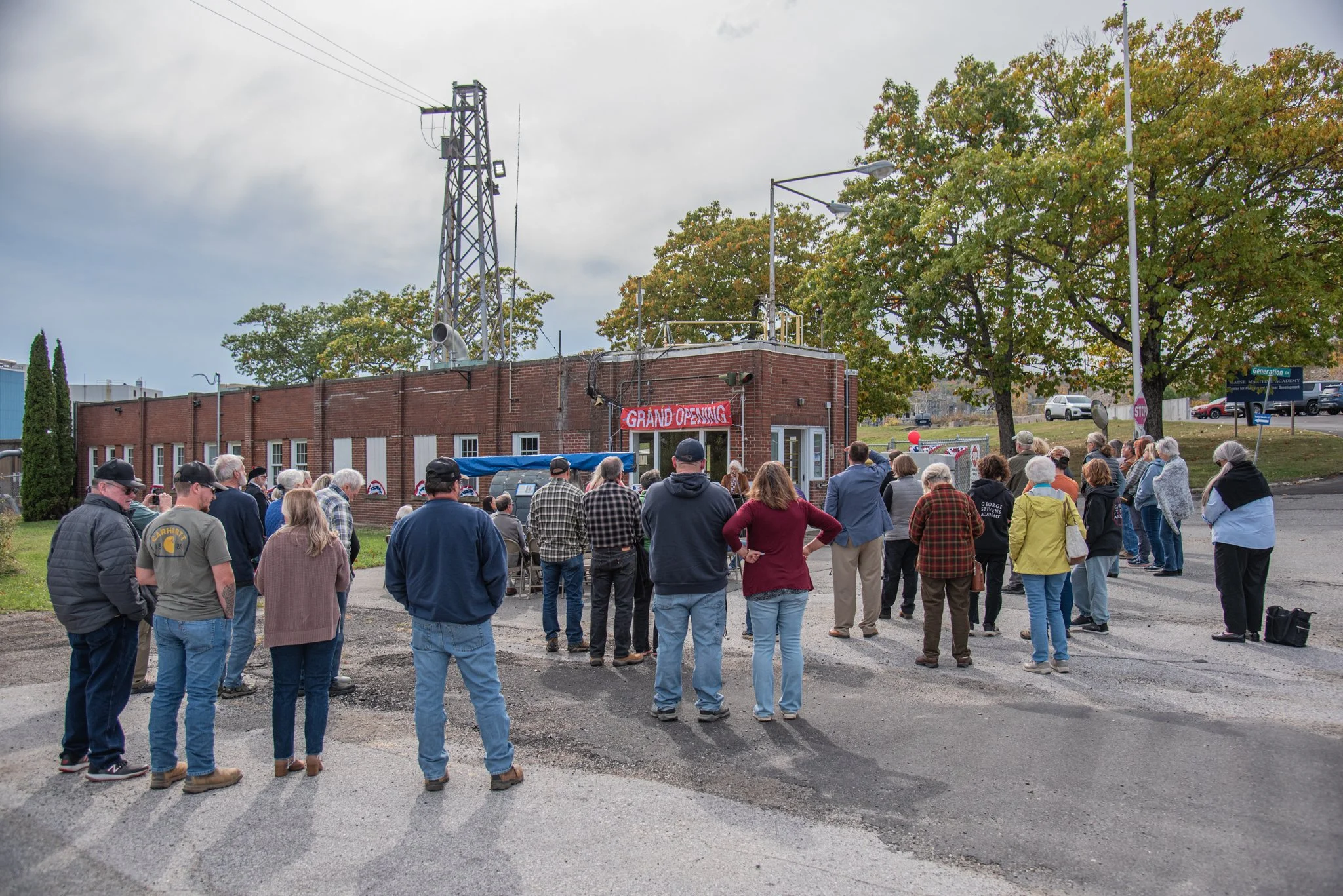 A group of people meeting in an unfinished room with brick walls that will be part of the Bucksport Paper Mill Museum.
