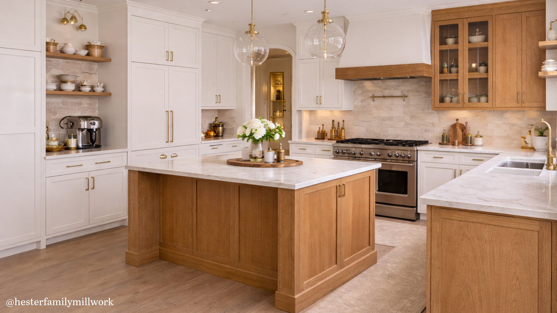 Custom kitchen cabinetry with painted perimeter cabinets and a stained wood island, showing a warm, balanced design with quartz countertops, glass pendants, and built-in storage