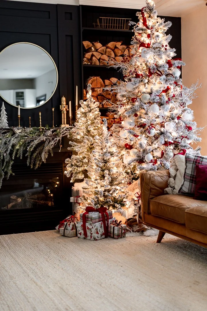 Custom living room built-in cabinetry with fireplace surround and shelving, styled for Christmas with a flocked tree, greenery, and layered holiday decor, showcasing timeless millwork and functional storage.