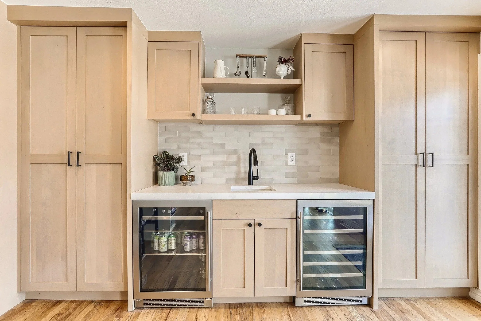 A home bar designed like fine furniture. Yes, please. Clean-lined Shaker cabinetry in a natural finish frames built-in wine + beverage coolers, while open shelving and a subtle backsplash keep the look light and modern.

Follow @hesterfamilymillwork 