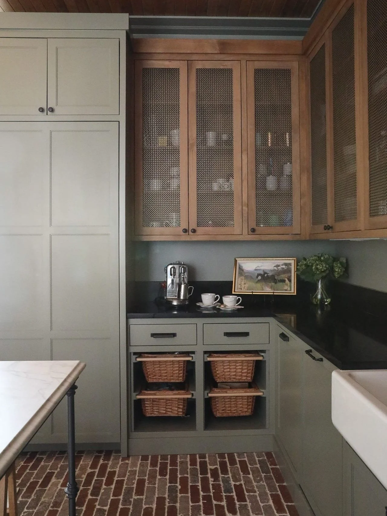 Thinking about painting your cabinets green? Read this first!
Muted greens like this one have become a designer favorite, and for good reason. They bring calm, warmth, and timeless character without feeling trendy. When paired with natural wood, blac