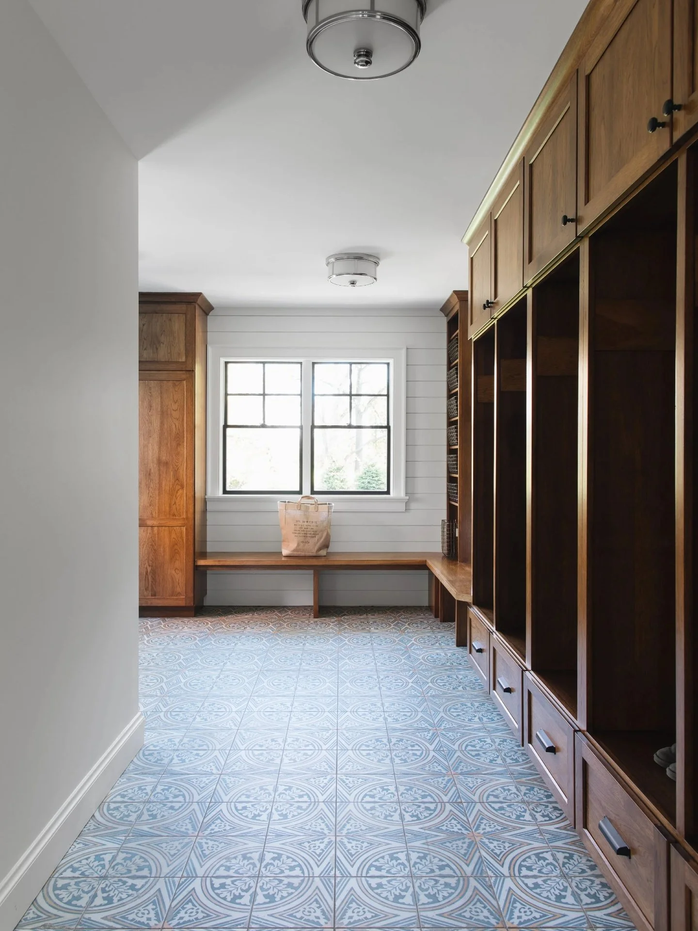 This storage hall is built for real life. Tall locker bays for coats and gear, basket shelves sized for daily essentials, and lower drawers that keep everything off the floor. The solid wood cabinetry, clean reveals, and continuous bench make the who