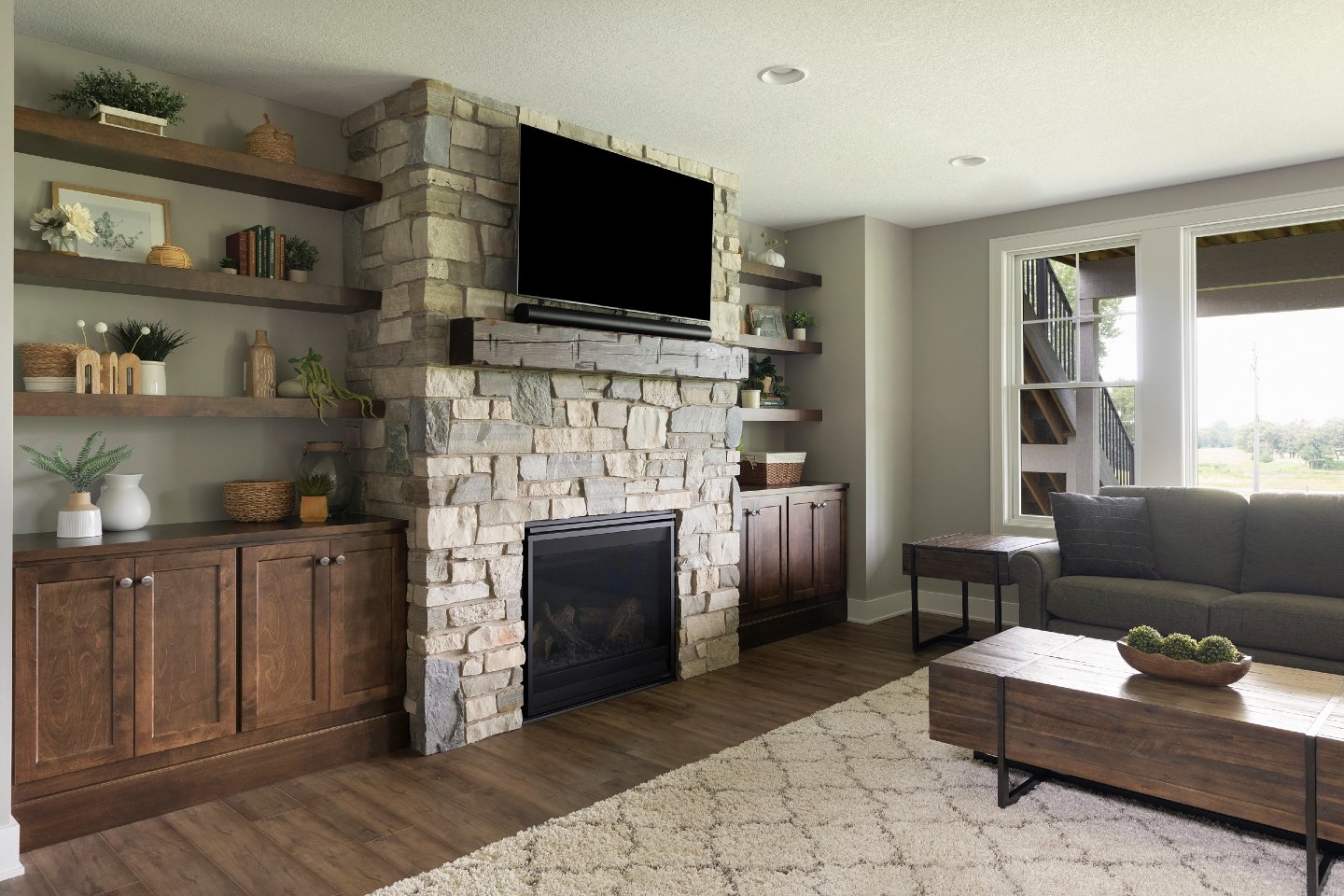 Warm wood built-ins, thick floating shelves, and a stone fireplace that turns a basement into a real living space. Every shelf is sized for styling, every cabinet for storage that actually gets used.

Which detail catches your eye first? Like, commen