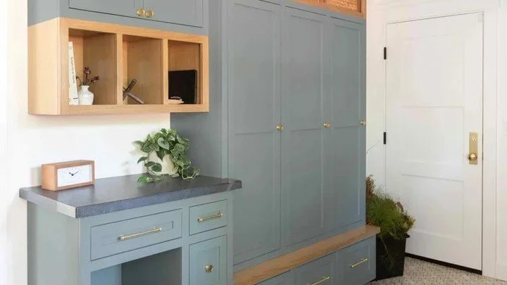 This entryway built in works because every function has a place. Tall cabinets handle bulk storage, open cubbies keep daily items visible, and the integrated pet station blends in instead of standing out. Painted cabinetry paired with natural wood ke