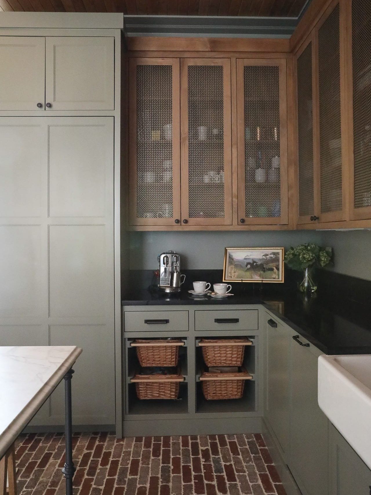 Thinking about painting your cabinets green? Read this first!
Muted greens like this one have become a designer favorite, and for good reason. They bring calm, warmth, and timeless character without feeling trendy. When paired with natural wood, blac