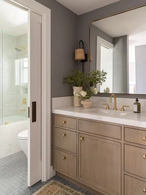 This is how you warm up a bathroom without making it feel heavy.
Light wood cabinetry keeps it grounded.
Brass adds contrast.
Clean stone keeps it bright.
It&rsquo;s a controlled mix, and that&rsquo;s why it works.

💾 Save this for your bathroom rem