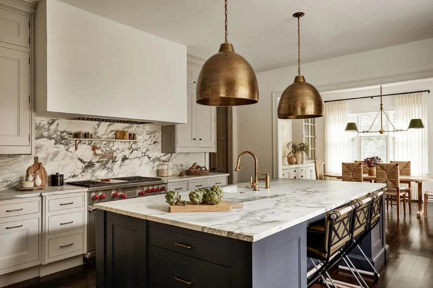 This is a really well-resolved kitchen.
The island depth and color give the space weight, while the perimeter cabinetry stays intentionally soft so the marble can read as a feature, not noise.

You also get a full-height slab backsplash, controlled h