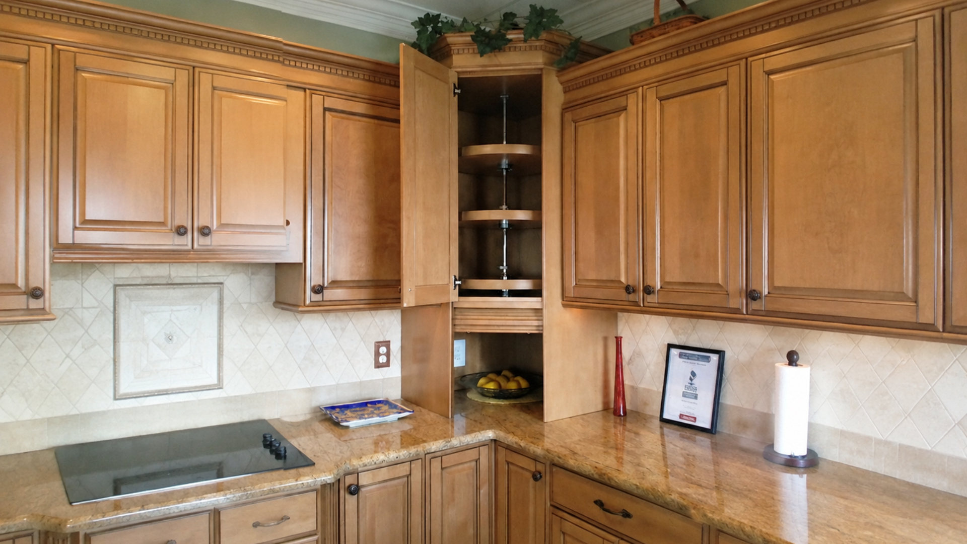 Custom gray countertop cabinet with open folding doors, interior dish storage, warm lighting, and U.S. electrical outlets.