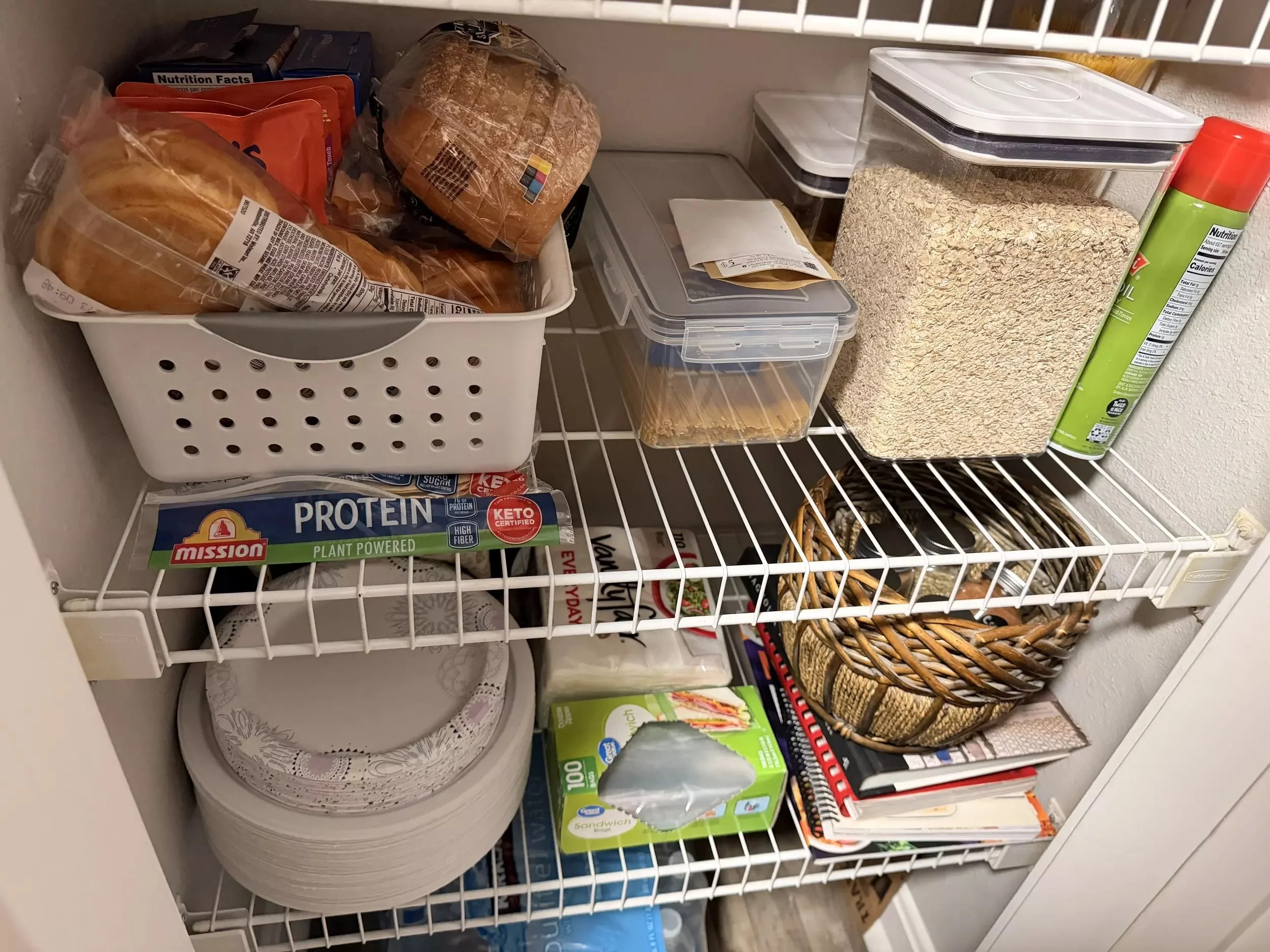 Builder grade pantry shelving with wire racks and mixed food storage, showing limited organization, crowded shelves, and inefficient use of vertical space in a small kitchen pantry.