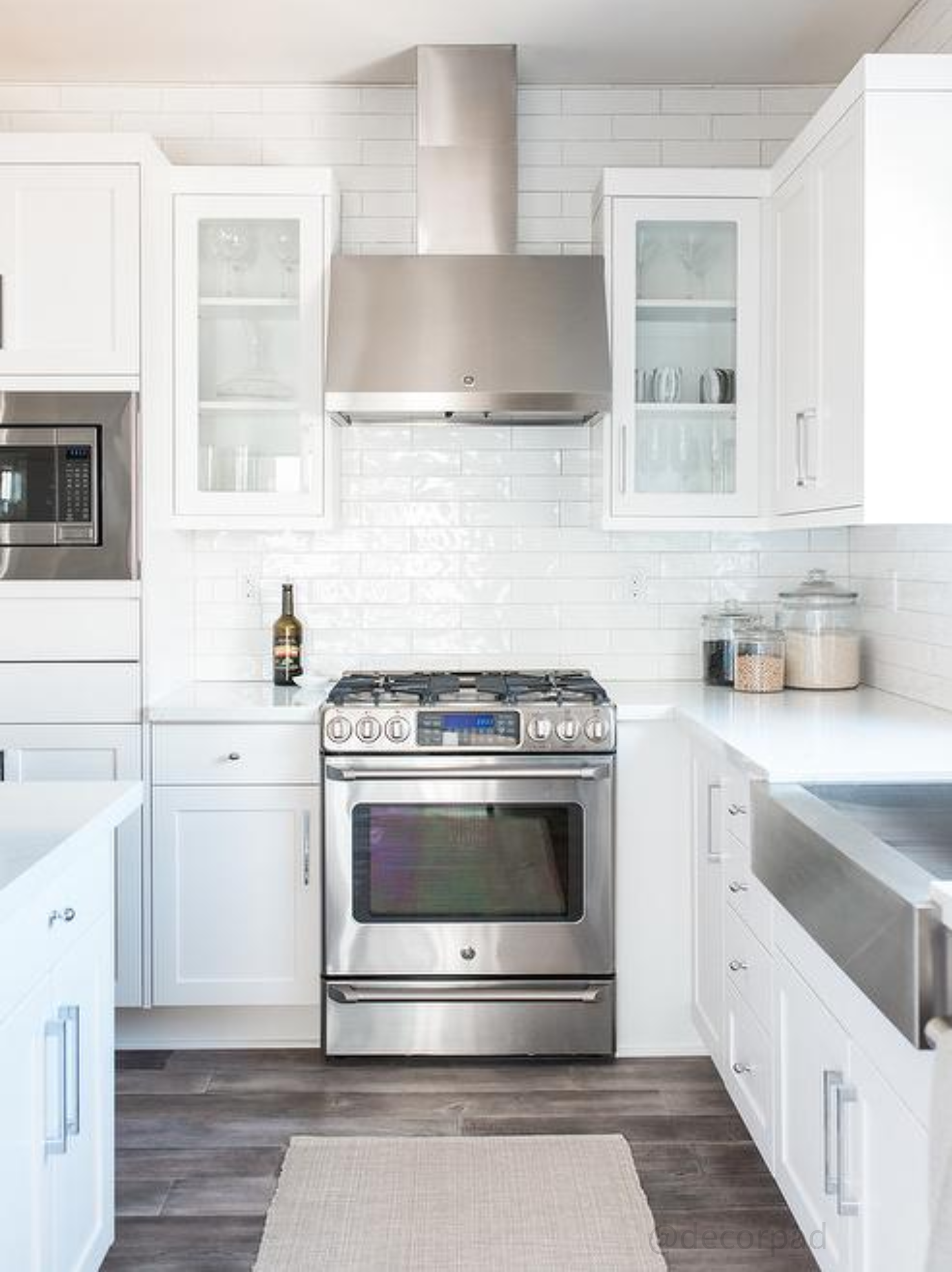 Warm custom kitchen with rich wood island cabinetry, hanging copper cookware, natural light, and timeless cabinetry design focused on functionality and everyday living.