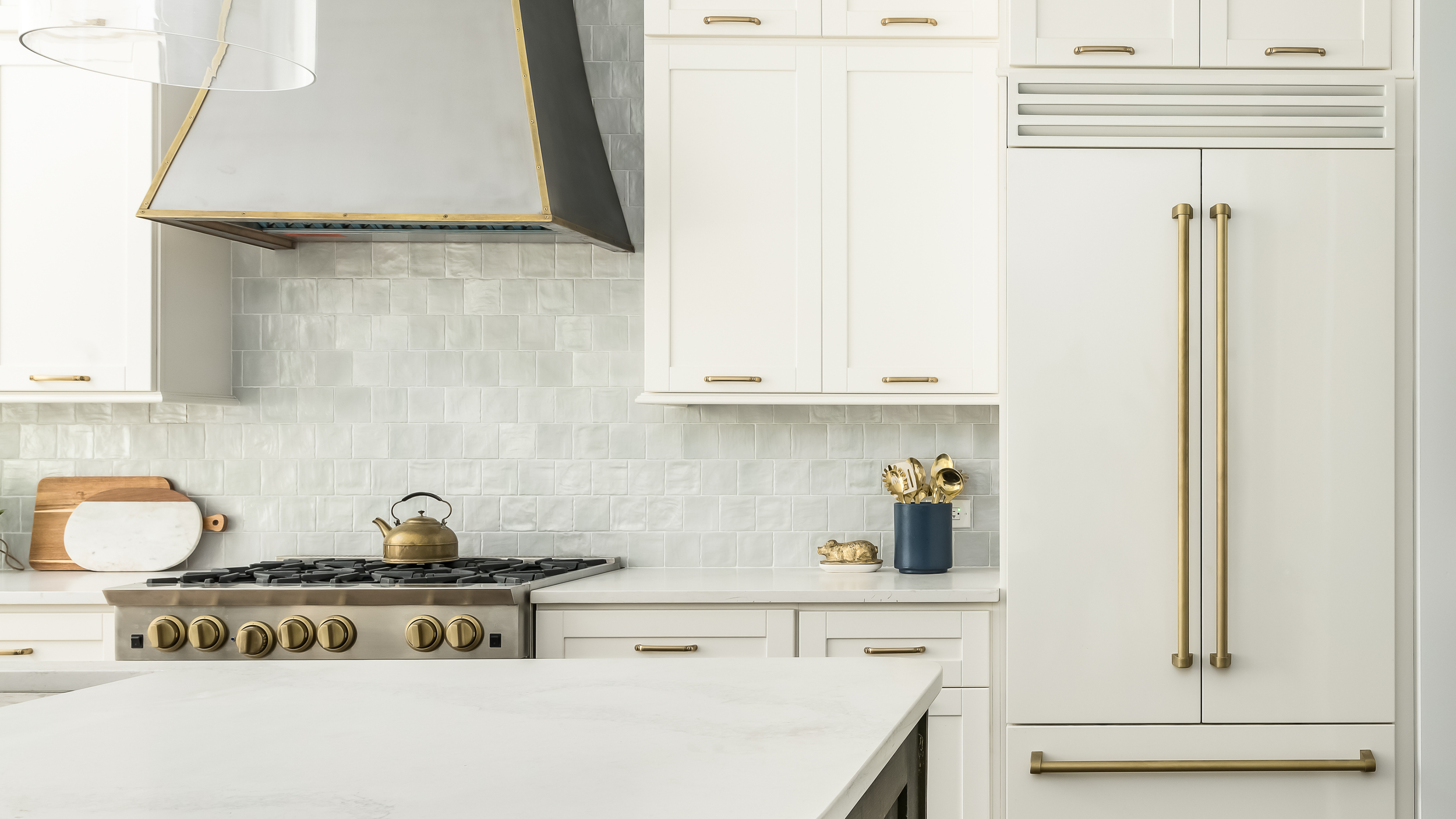 White Shaker kitchen cabinets with brass hardware by Hester Family Millwork