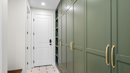 Green built-in entryway cabinets with brass hardware
