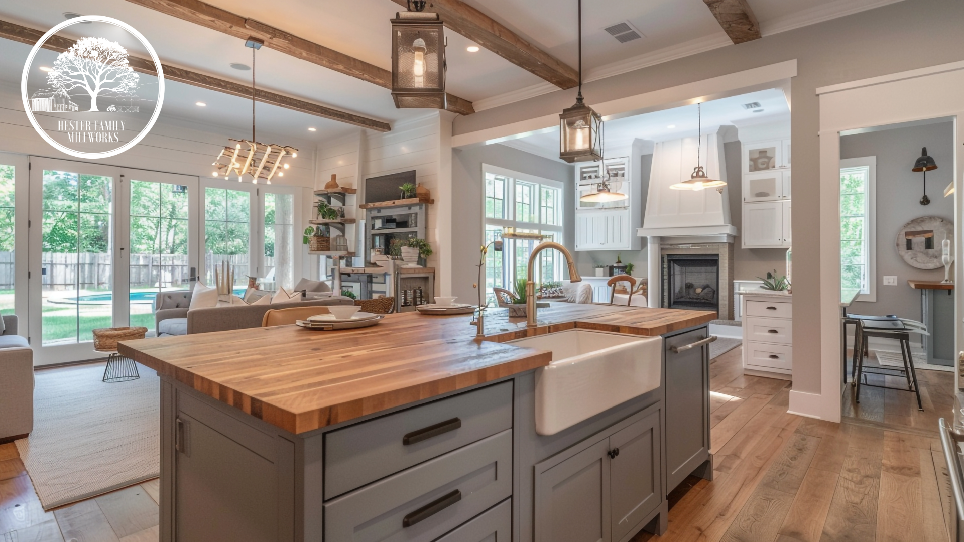 Open concept farmhouse kitchen with butcher block island, gray shaker cabinetry, layered lighting, and warm natural wood finishes