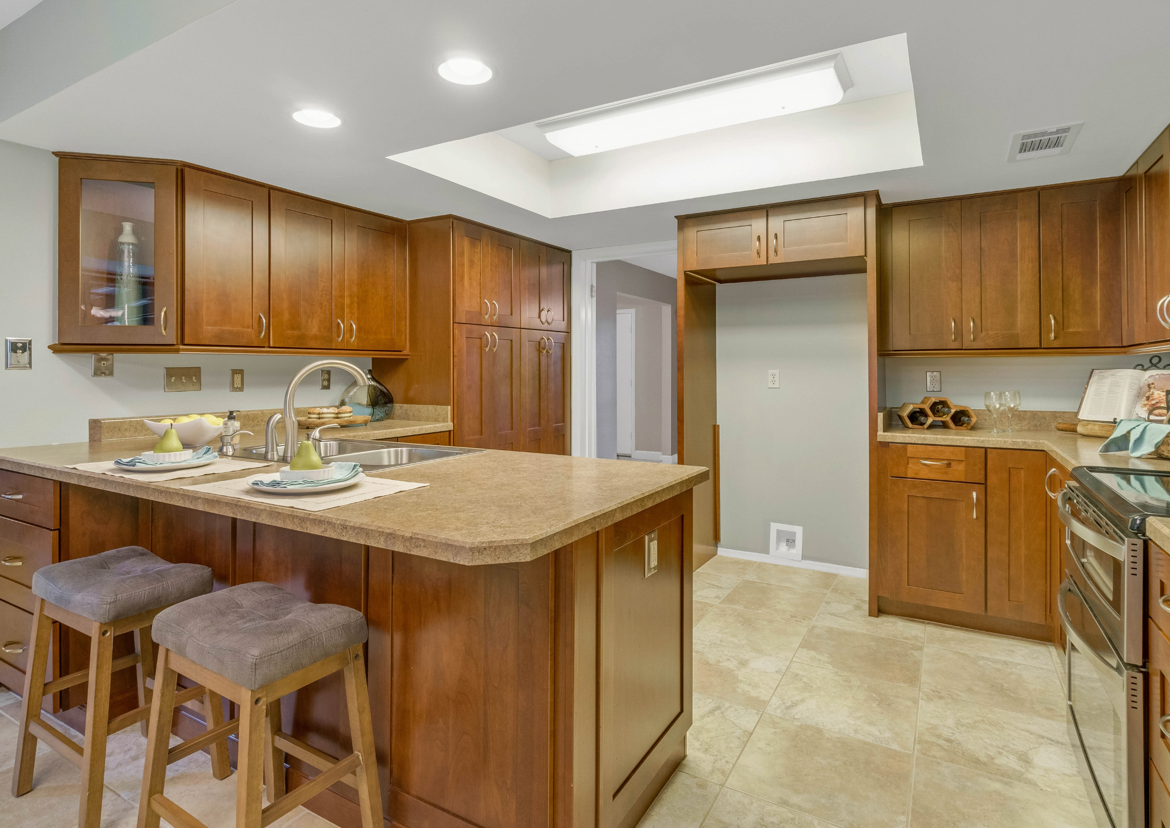 Outdated builder-grade kitchen with dark wood cabinets and basic layout, representing common frustrations that lead homeowners to consider moving instead of remodeling