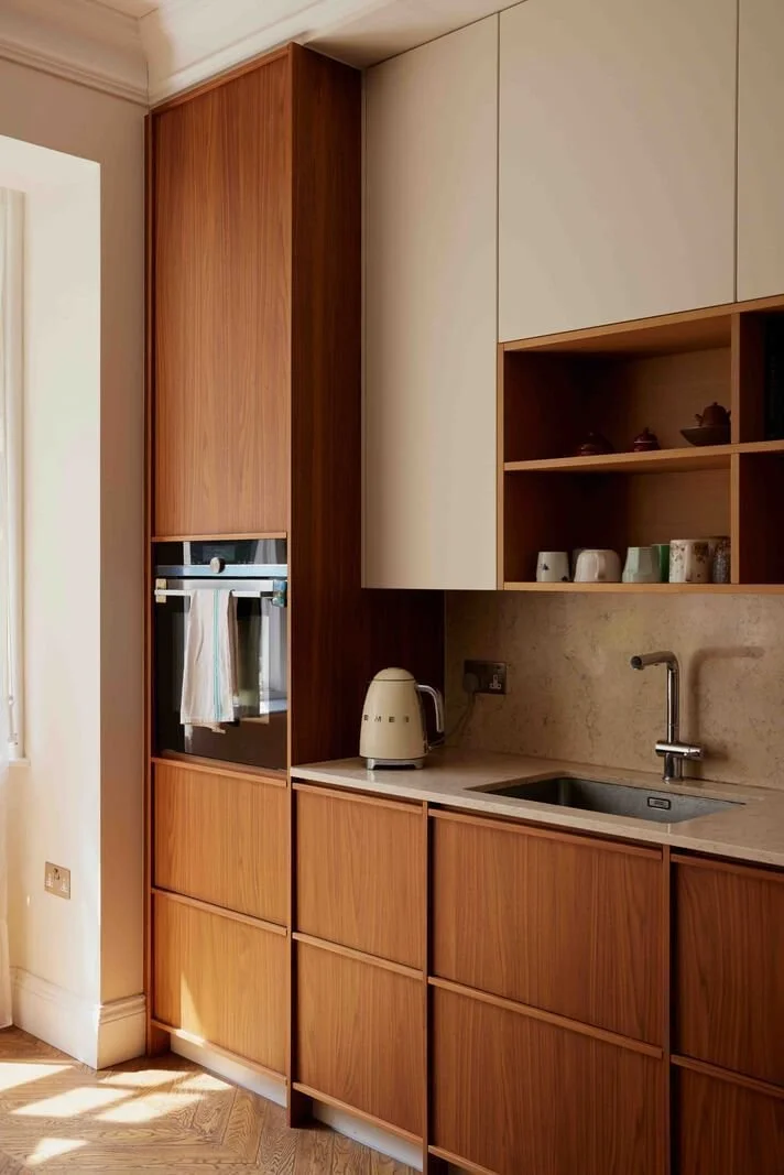 Slab style kitchen cabinetry with flat-panel wood cabinet doors, neutral upper cabinets, integrated appliances, and open shelving, showcasing modern cabinetry design with warm natural tones.