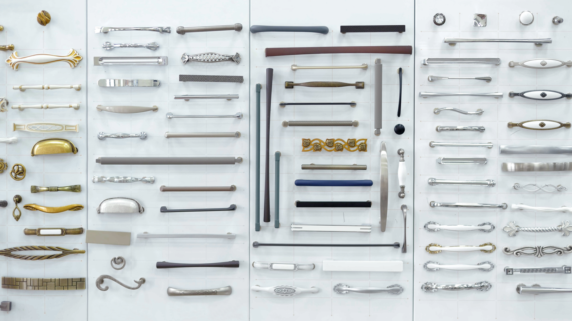 Assorted cabinet hardware samples, including knobs and pulls in multiple finishes, displayed on a sample board.