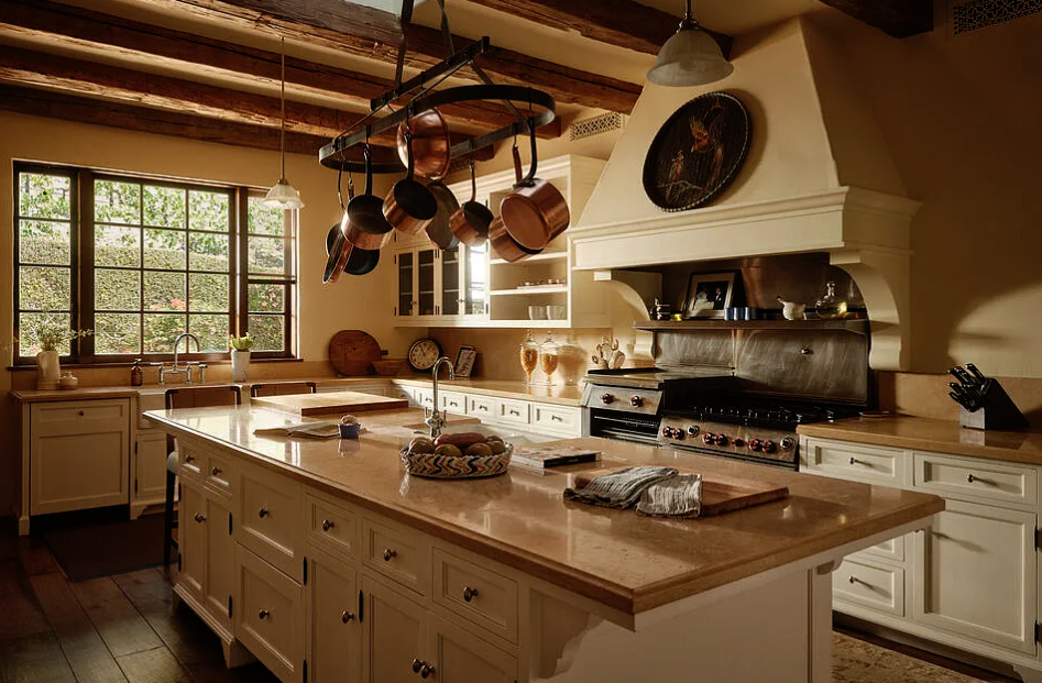 Nostalgic kitchen with white cabinets, a central island, hanging copper pots, and a wood-paneled ceiling.