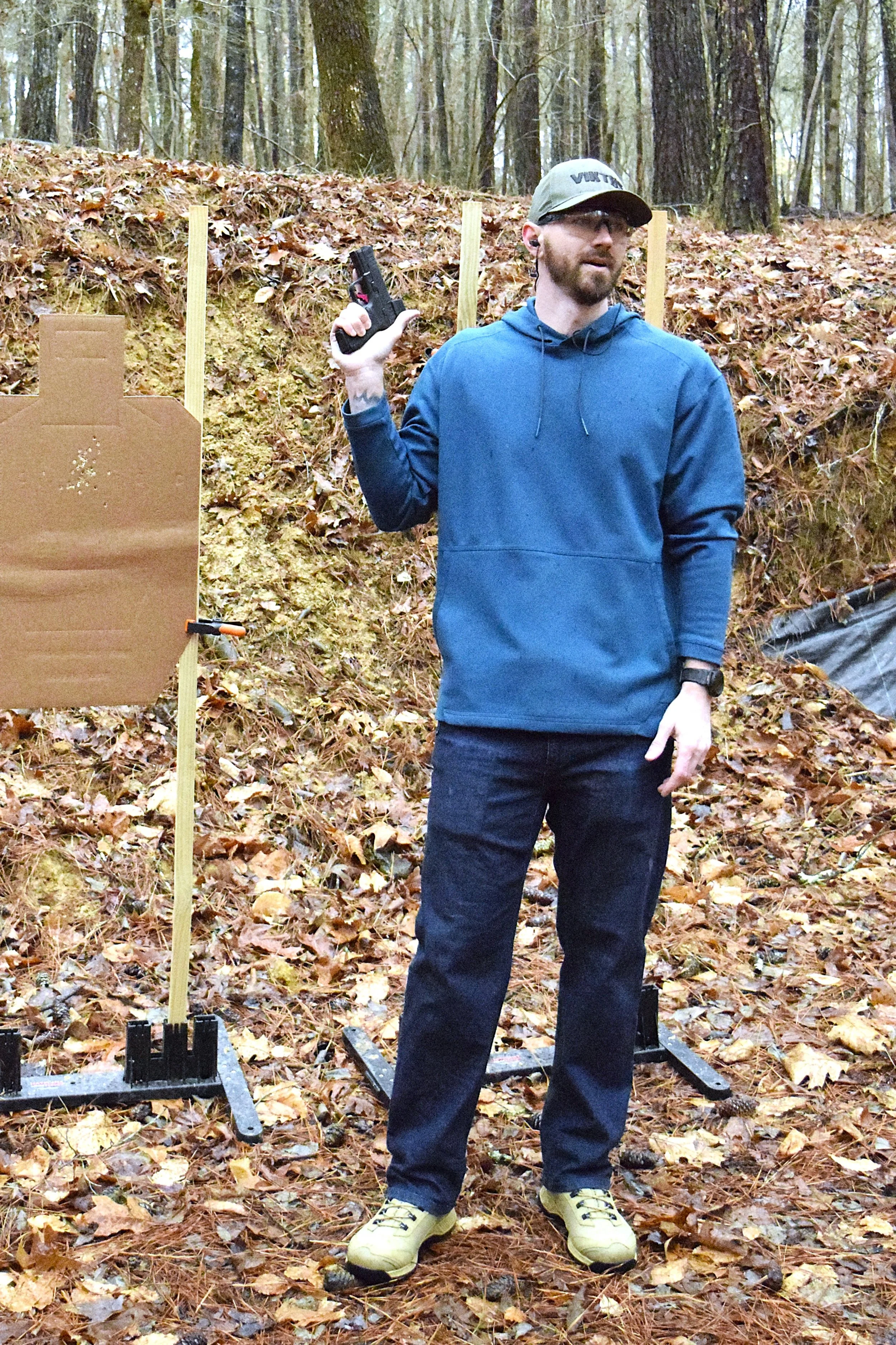 Ethan, lead instructor, speaking to students at a firearms training range.