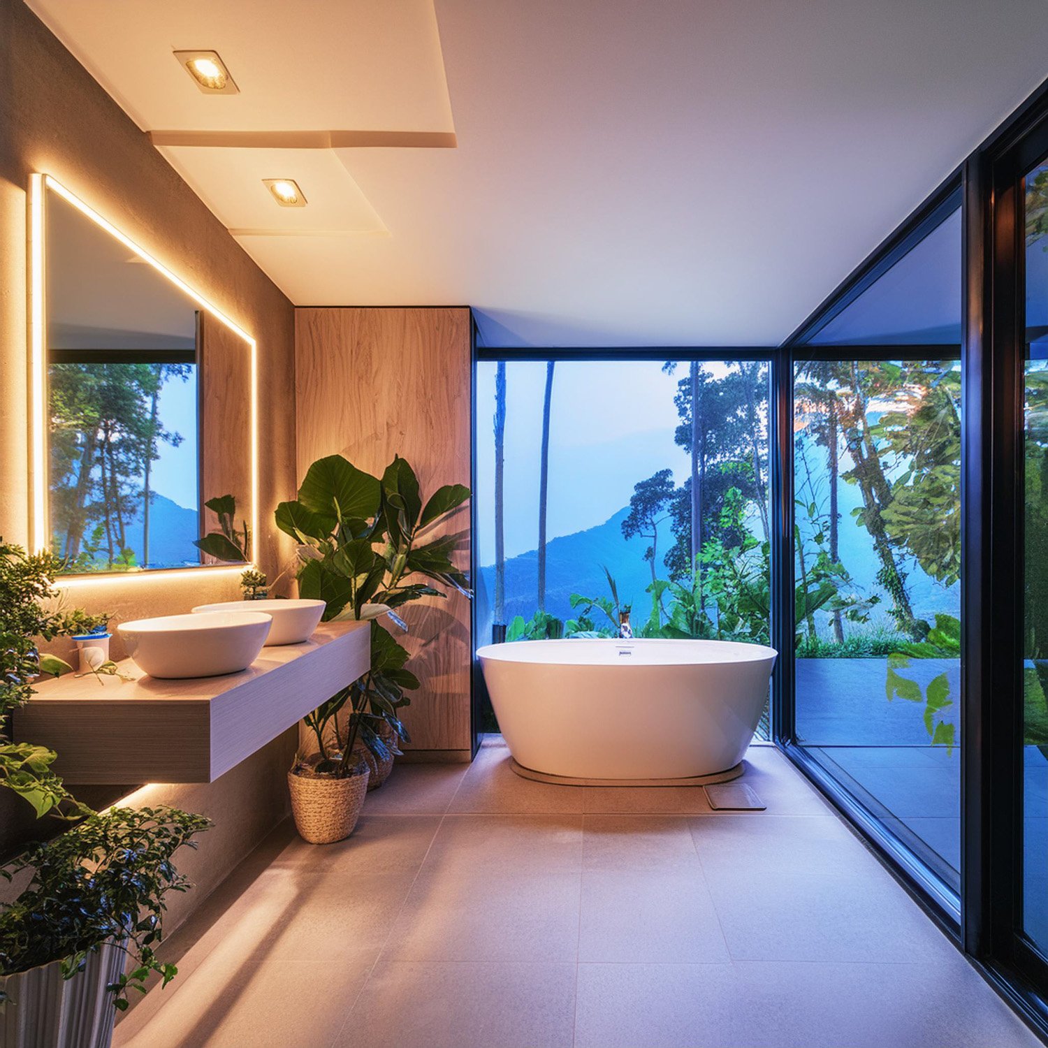 Modern bathroom with a freestanding bathtub, large window with a scenic outdoor view, double sinks, and indoor plants for decoration.
