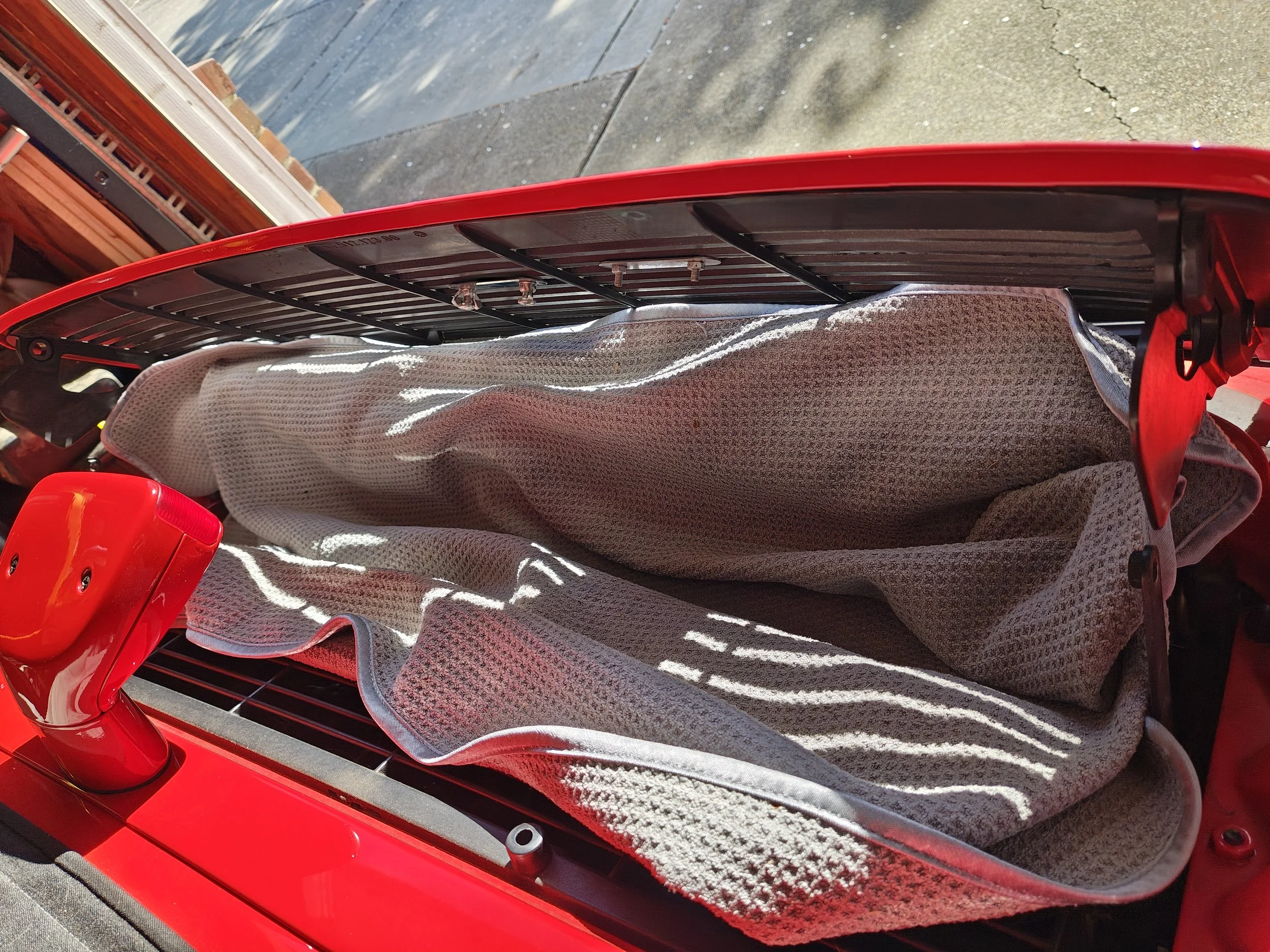 I suggest stuffing a towel in this area as you may drop screws and this prevents them from falling into the engine bay.  It sucks.