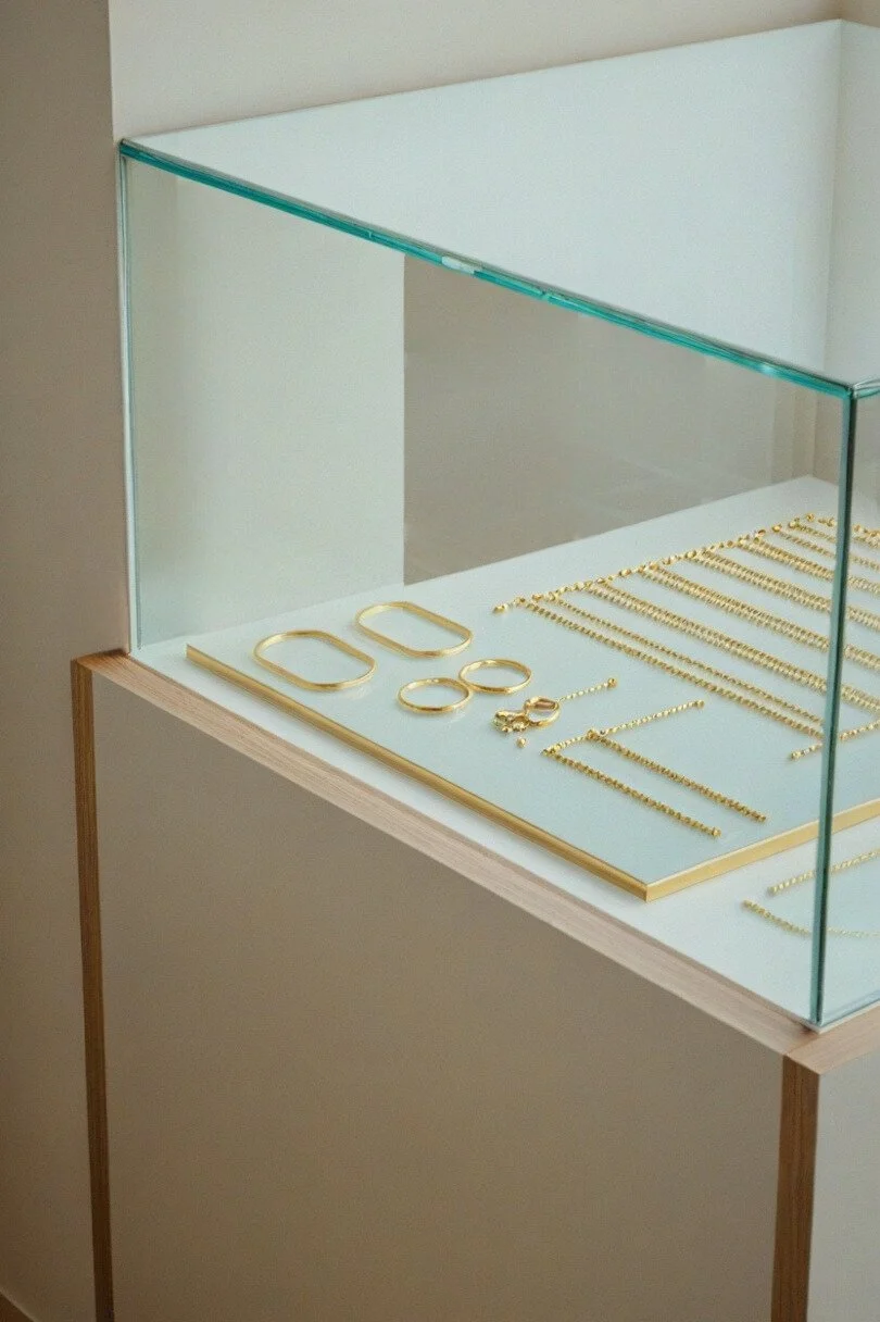 Jewelry display case with gold bracelets, rings, and necklaces