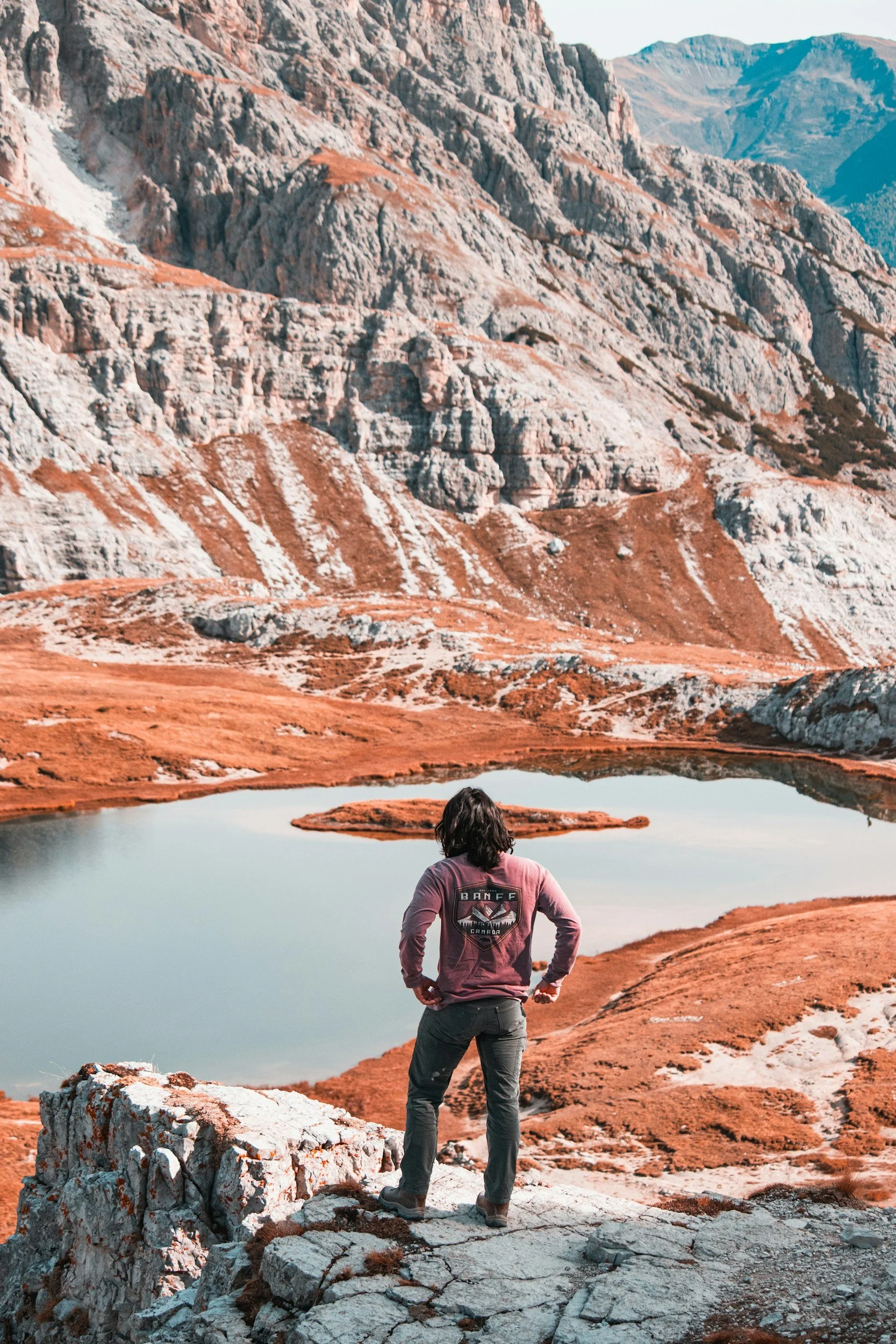 Man stares out at lake after climbing a mountain