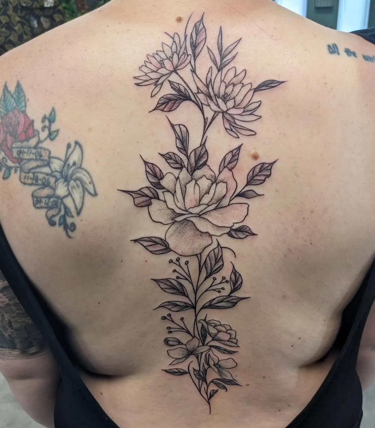 A beautiful, delicate floral spine tattoo done by owner/artist @infinite_enigma 💐 Ed specializes in all things black &amp; grey, sacred geometry, realism, and has done hundreds, if not thousands, of floral tattoos throughout his career! You can reac