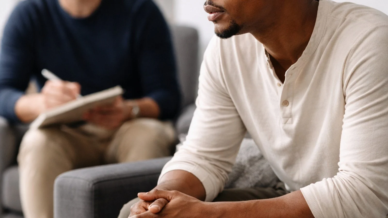 Male client in therapy session reflecting during conversation about CBT vs. psychodynamic therapy for men in San Francisco.