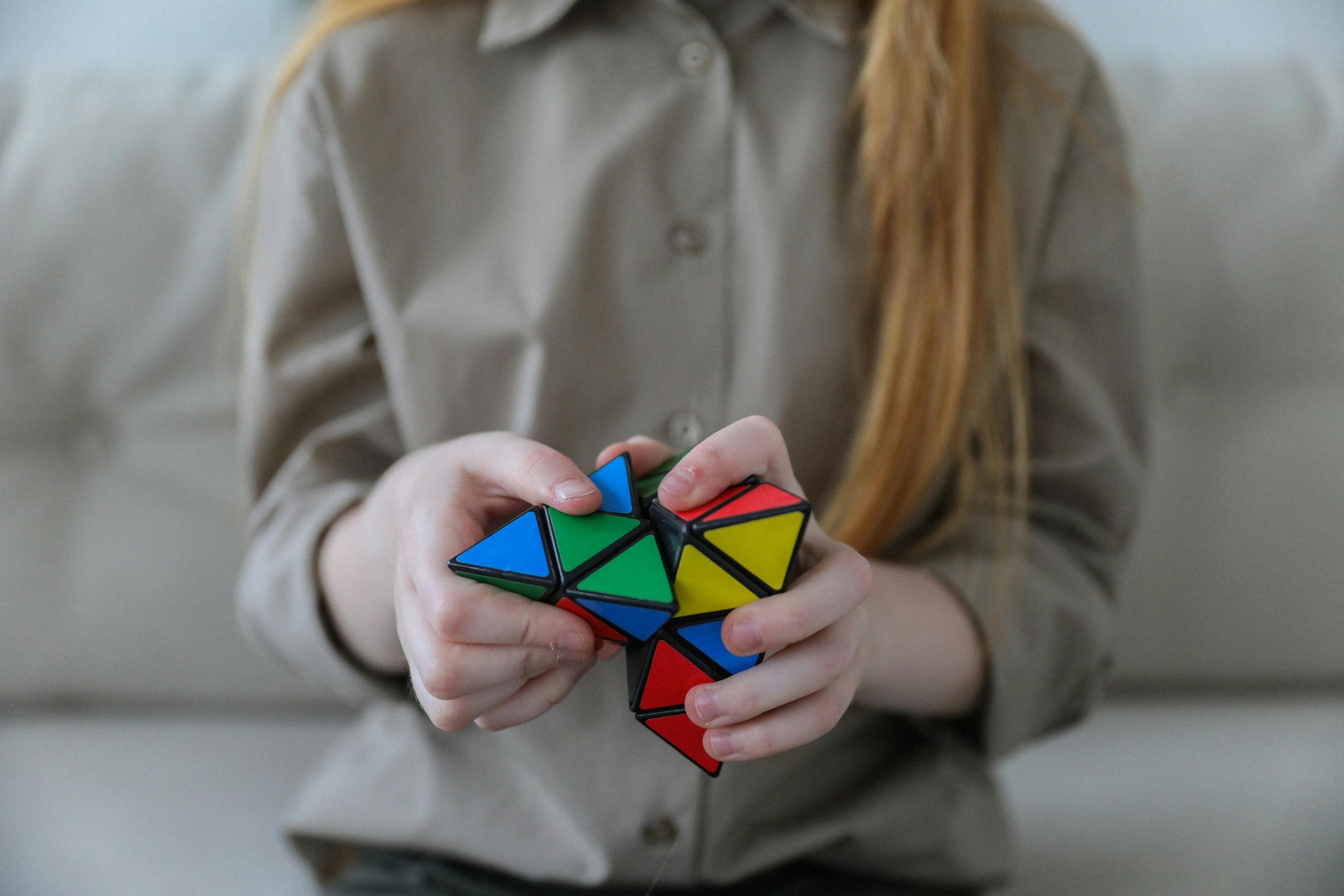 Hands twisting a colorful puzzle, symbolizing the careful untangling of past emotional patterns through psychodynamic psychotherapy.