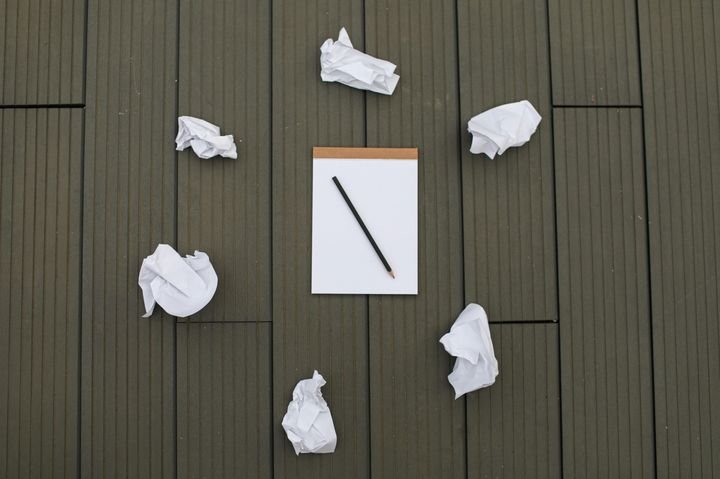 Crumpled paper around a blank notepad symbolizing starting over and navigating major life transitions.