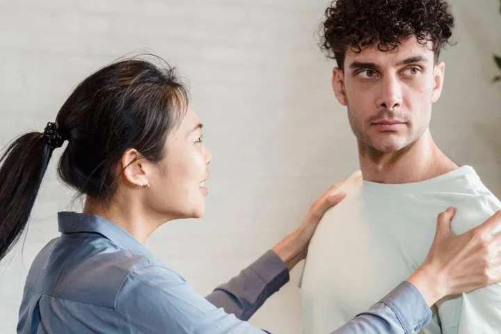 Man emotionally shutting down while his partner tries to connect during an argument, illustrating communication difficulties and therapy for men.