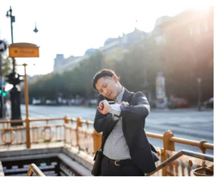 Man checking his watch outdoors symbolizing the frustration and waiting that can happen when a partner isn’t ready for couples therapy.