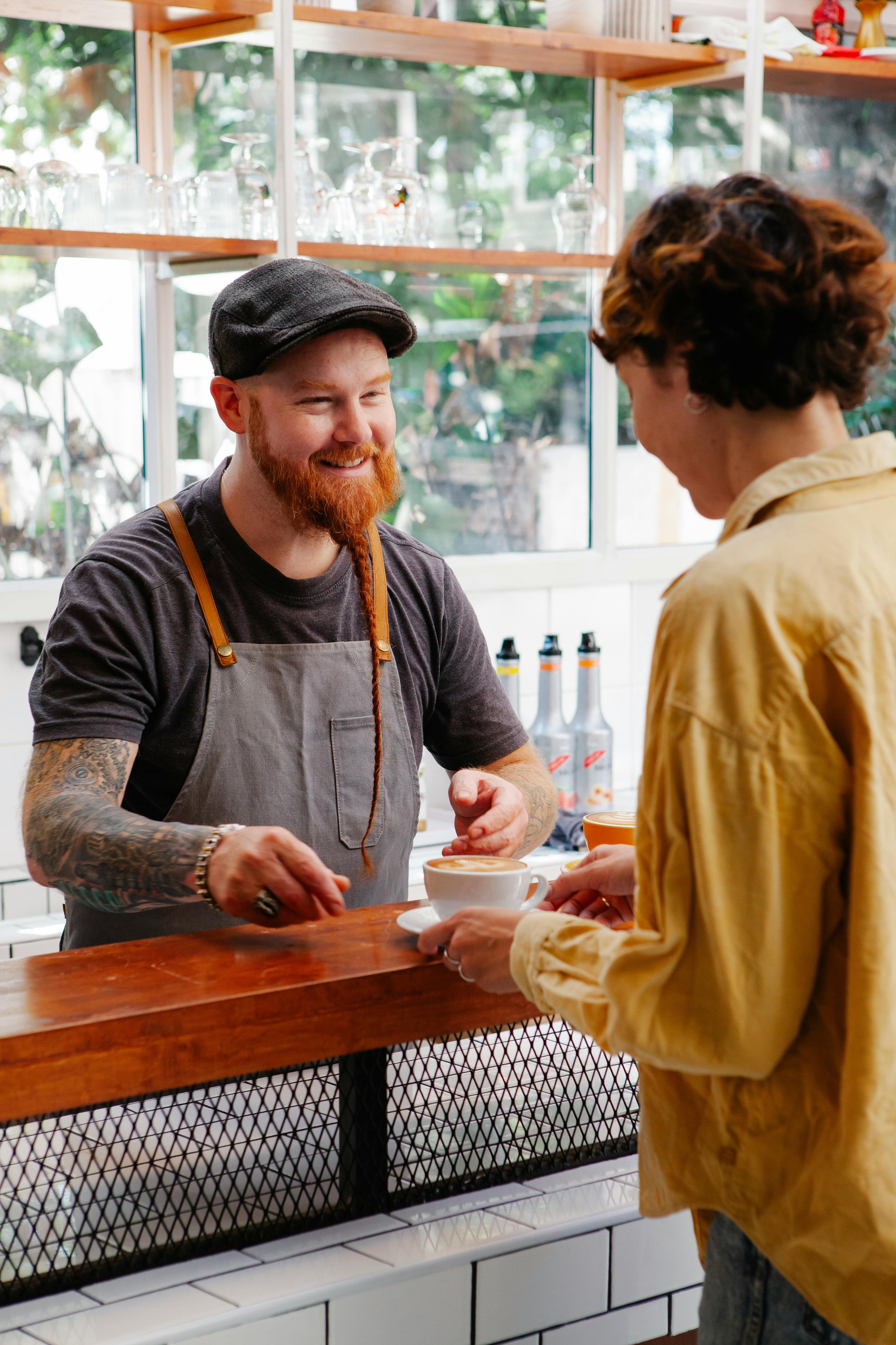 A friendly interaction between two people in a workplace setting, symbolizing the importance of creating safe and inclusive spaces for all identities.