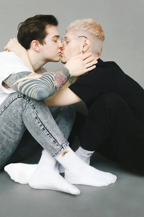 Gay couple sharing an intimate moment while sitting together, representing emotional and physical intimacy challenges addressed in relationship counseling in San Francisco.