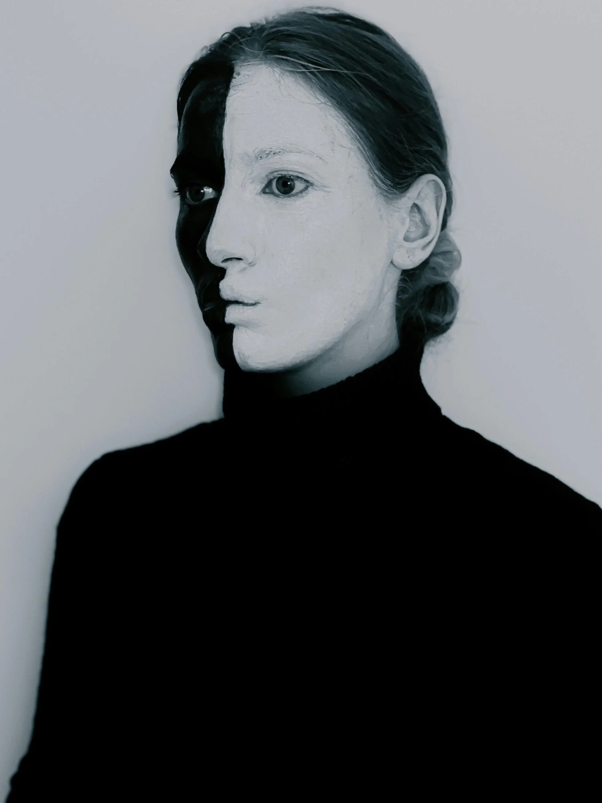 A face painted in contrasting light and dark tones, symbolizing the emotional polarity and depth explored in psychodynamic therapy for bipolar disorder.