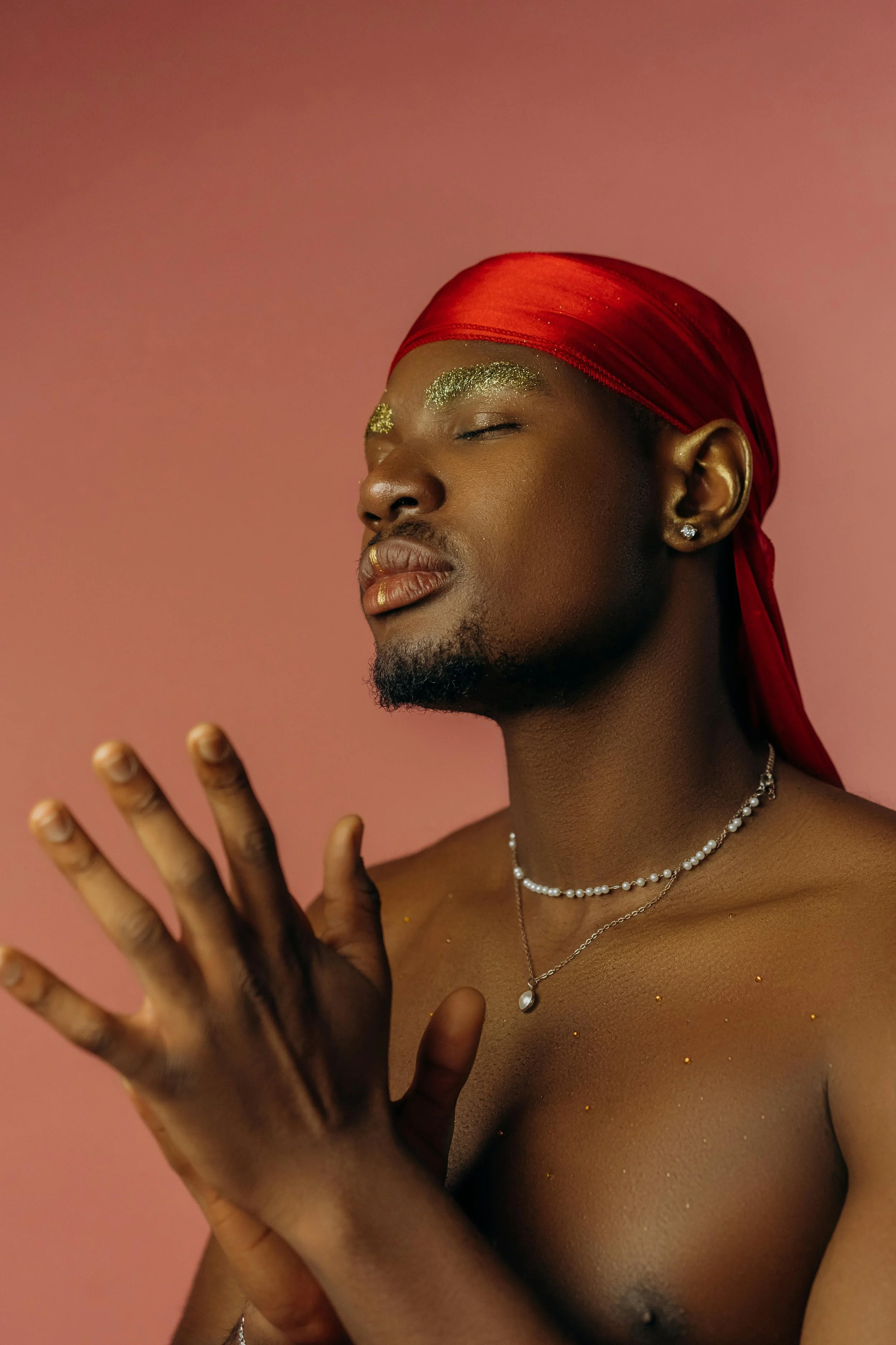A person posing with soft expression and glitter accents, symbolizing men’s exploration of femininity and the freedom to embrace an authentic self.