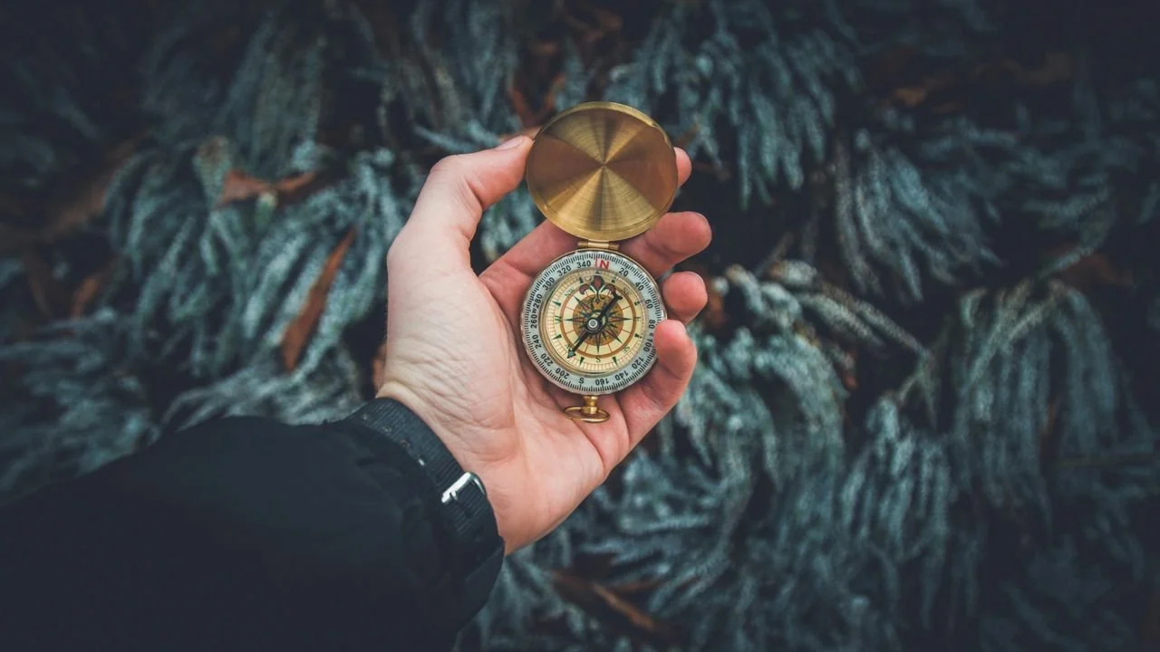 Hand holding an antique compass, symbolizing feeling lost and finding direction through therapy.