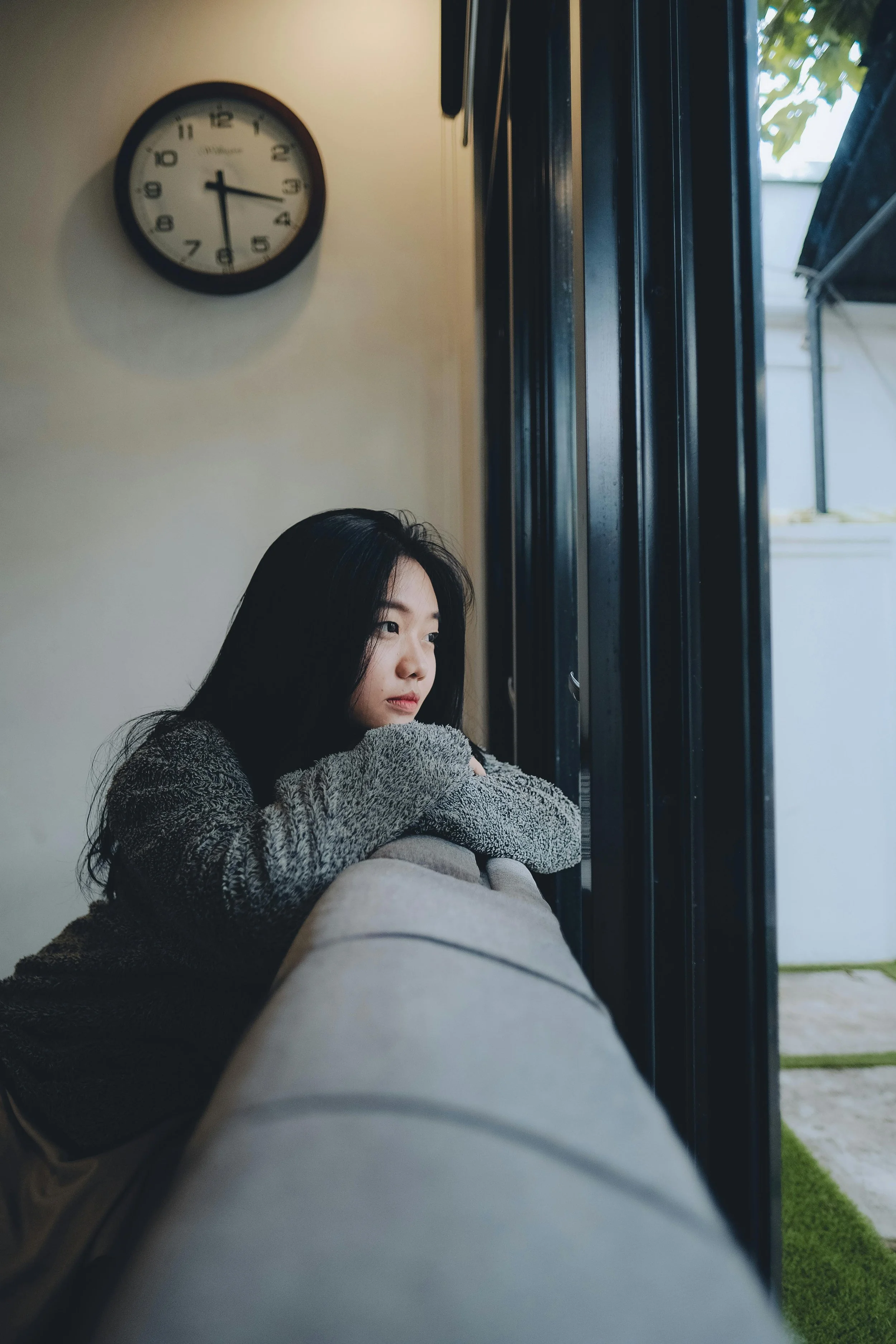 A person looking out a window with a pensive expression, symbolizing the reflection and uncertainty often experienced in unbalanced or emotionally abusive relationships.