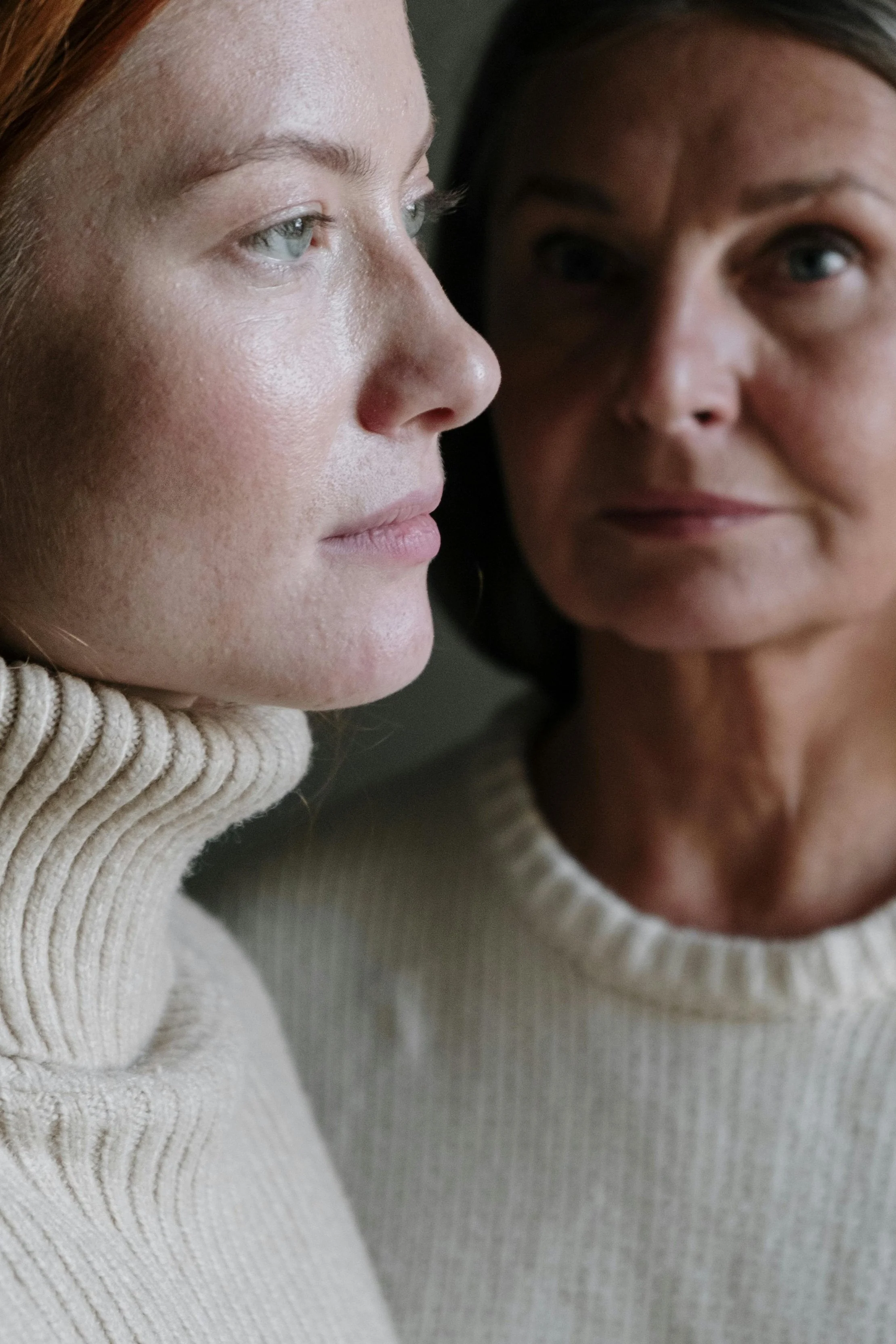Two generations of women standing closely together, symbolizing how family narratives and inherited stories shape personal identity.