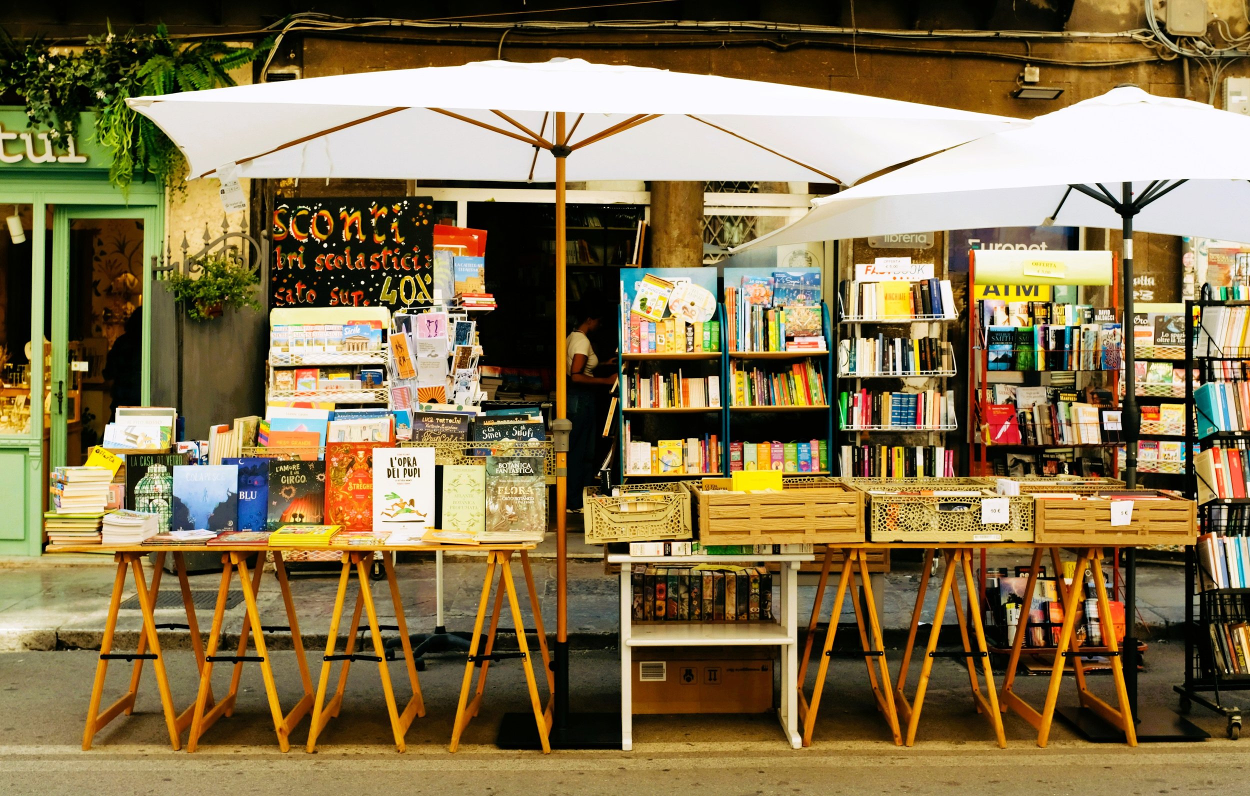 umbrellas over books on table outside pretty bookstore