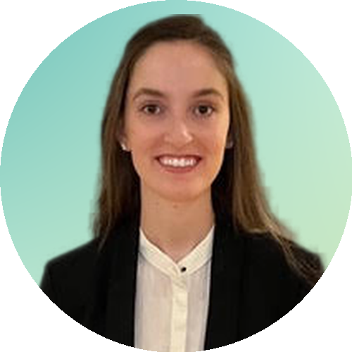 Young woman smiling with black blazer and white button up shirt and brown hair against a green background.